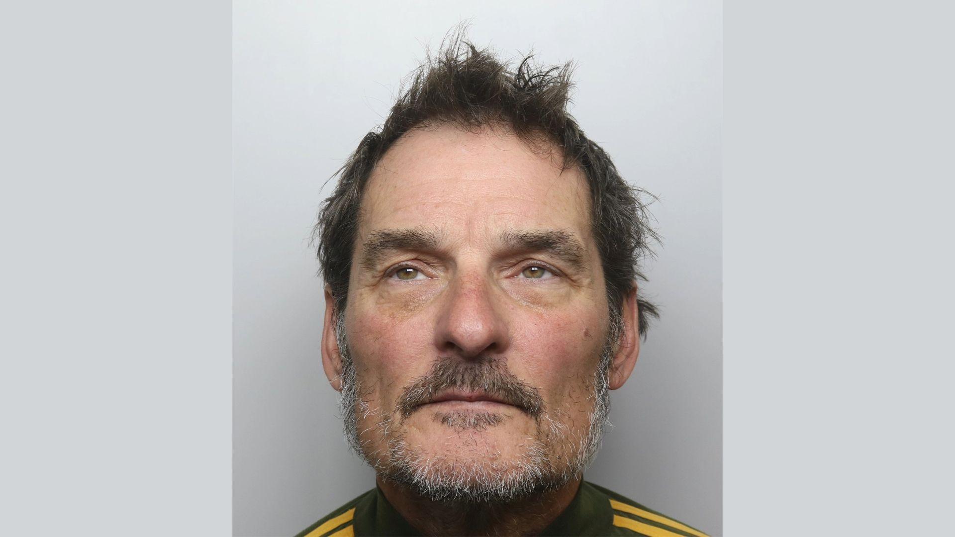 David Jordan, a man with spikey brown hair and a short beard, pictured against a grey background