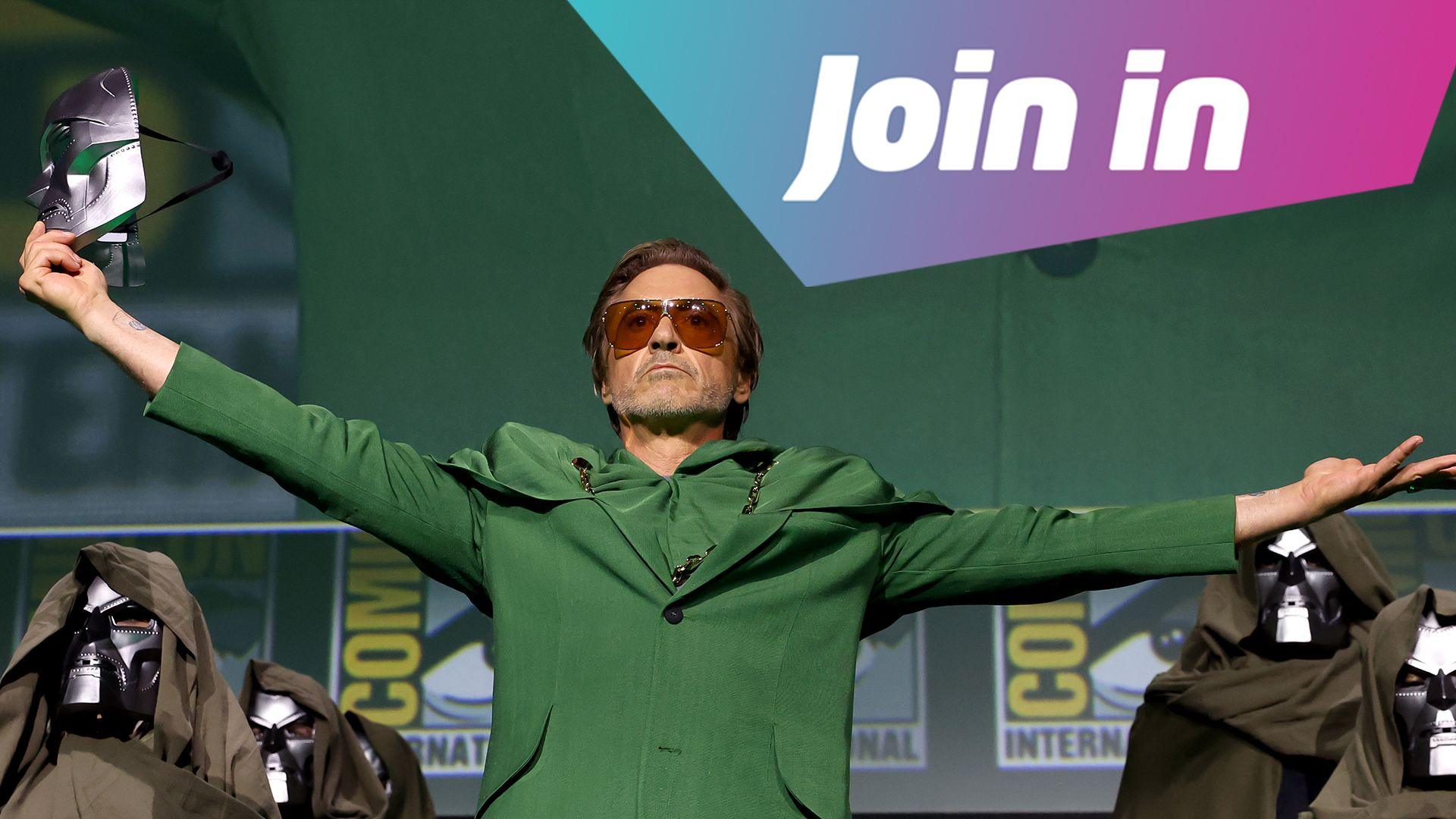 Robert Downey Jr stands with arms outstretched at Comic-Con, holding a mask. The image has text reading "Join in"