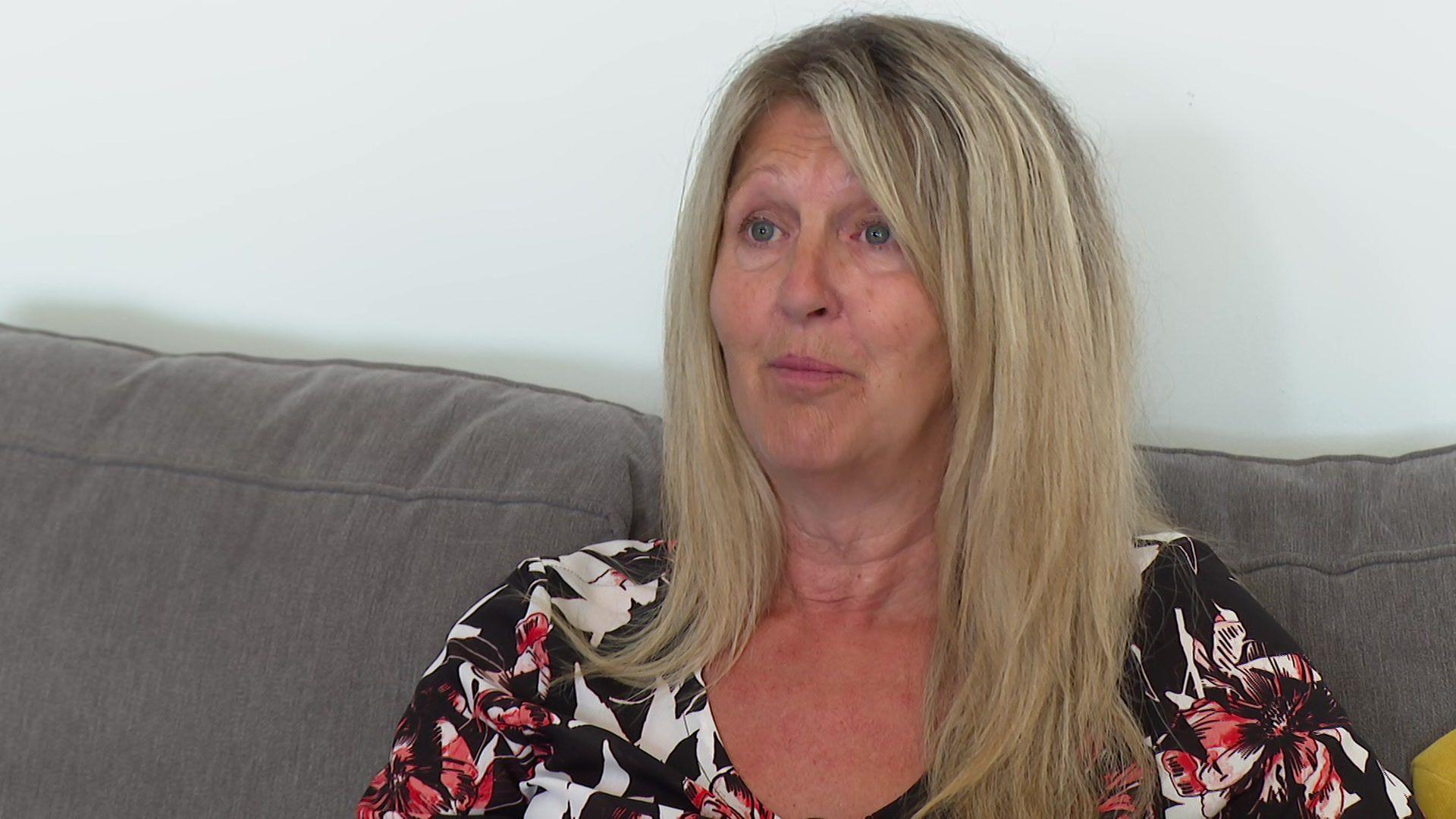 Elaine Buckle yn eistedd ar soffa yn ei chartref