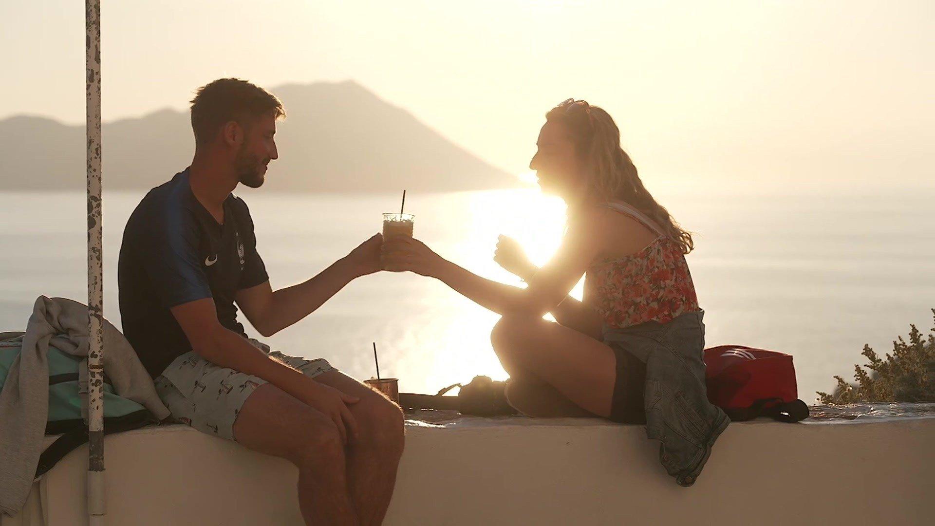 Two people sitting in front of the coast