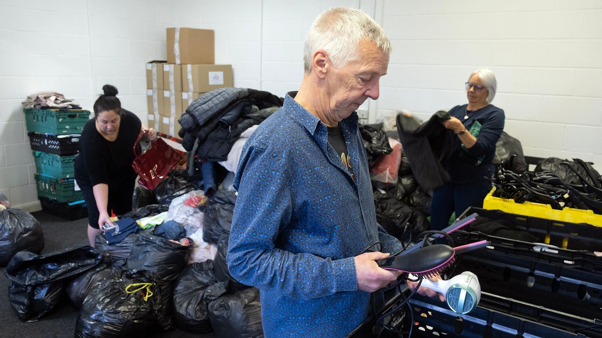 Angela Charlton and Michael Taylor, and operations manager Amy Sturdy, sorting through some of the many donations