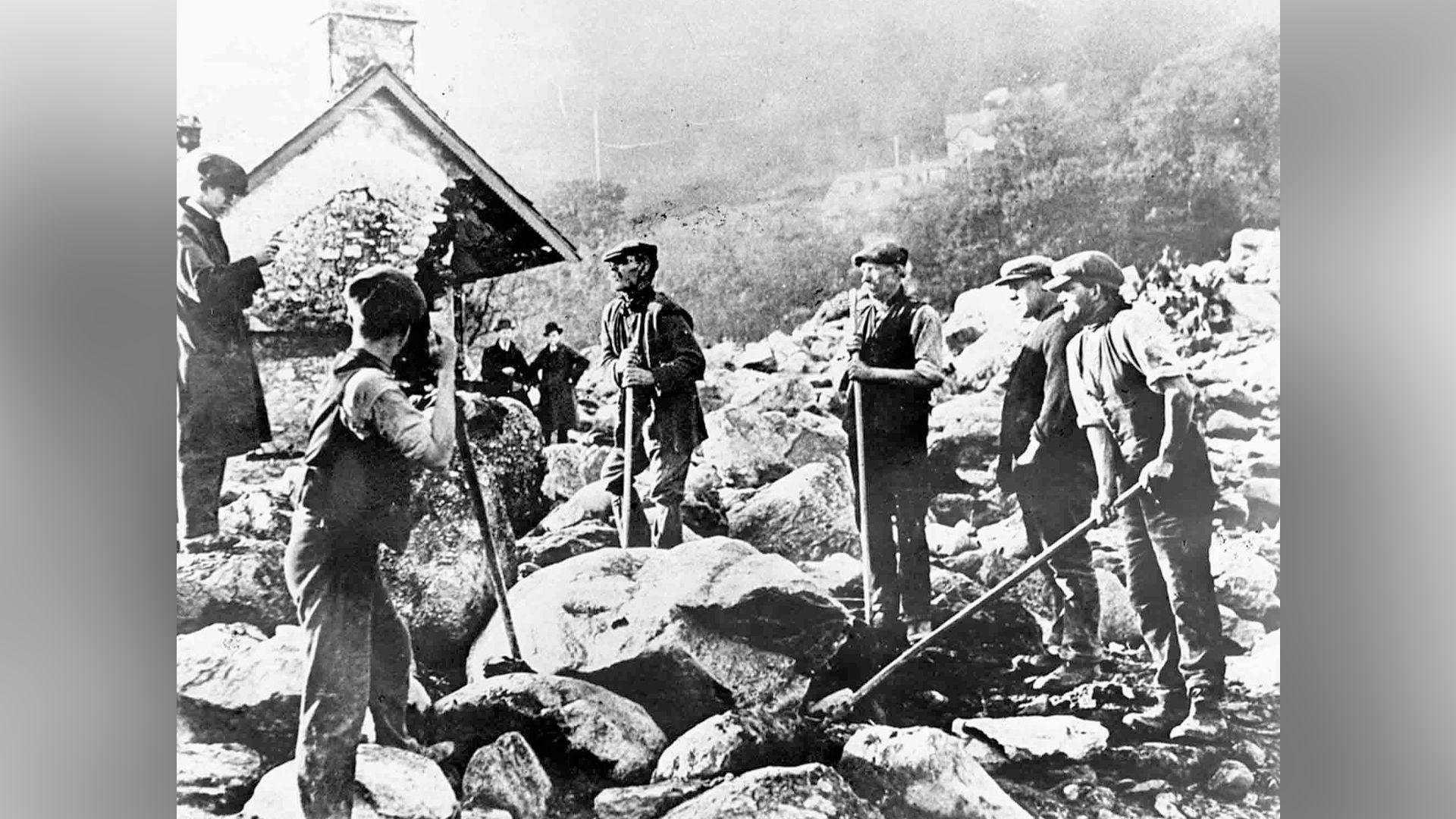 Dynion yn ceisio symud y rwbel