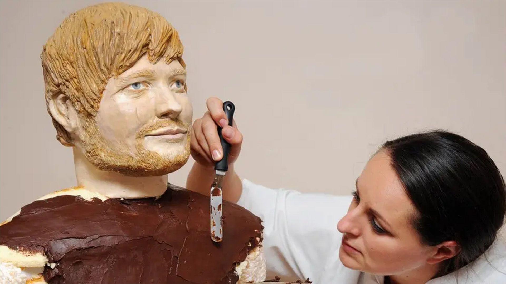 Lara is using a palette knife to smooth out chocolate on the life-life cake sculpture of Ed Sheeran. 