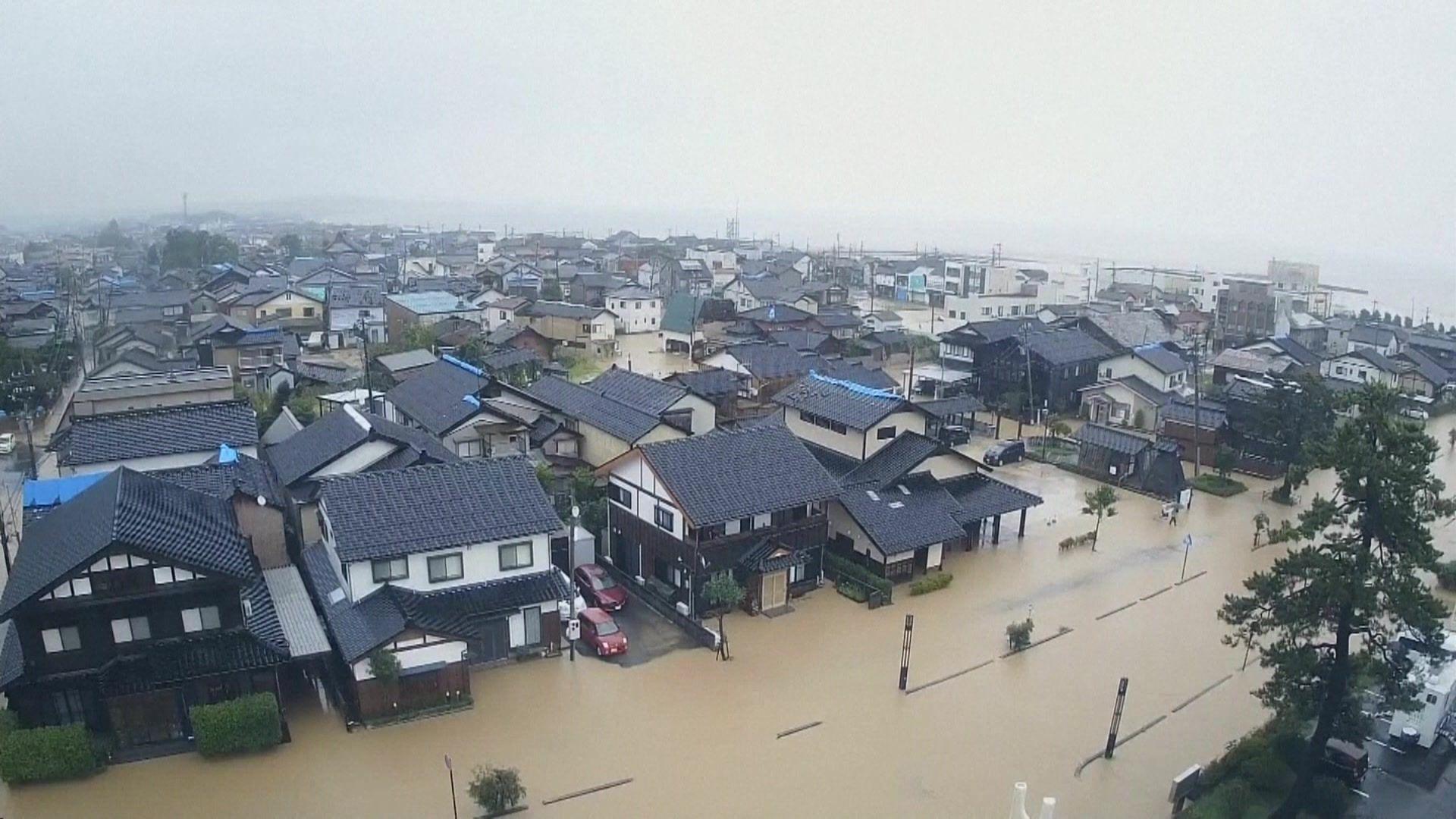 An aerial photo showing brown flood water covering roads in the region of Ishikawa