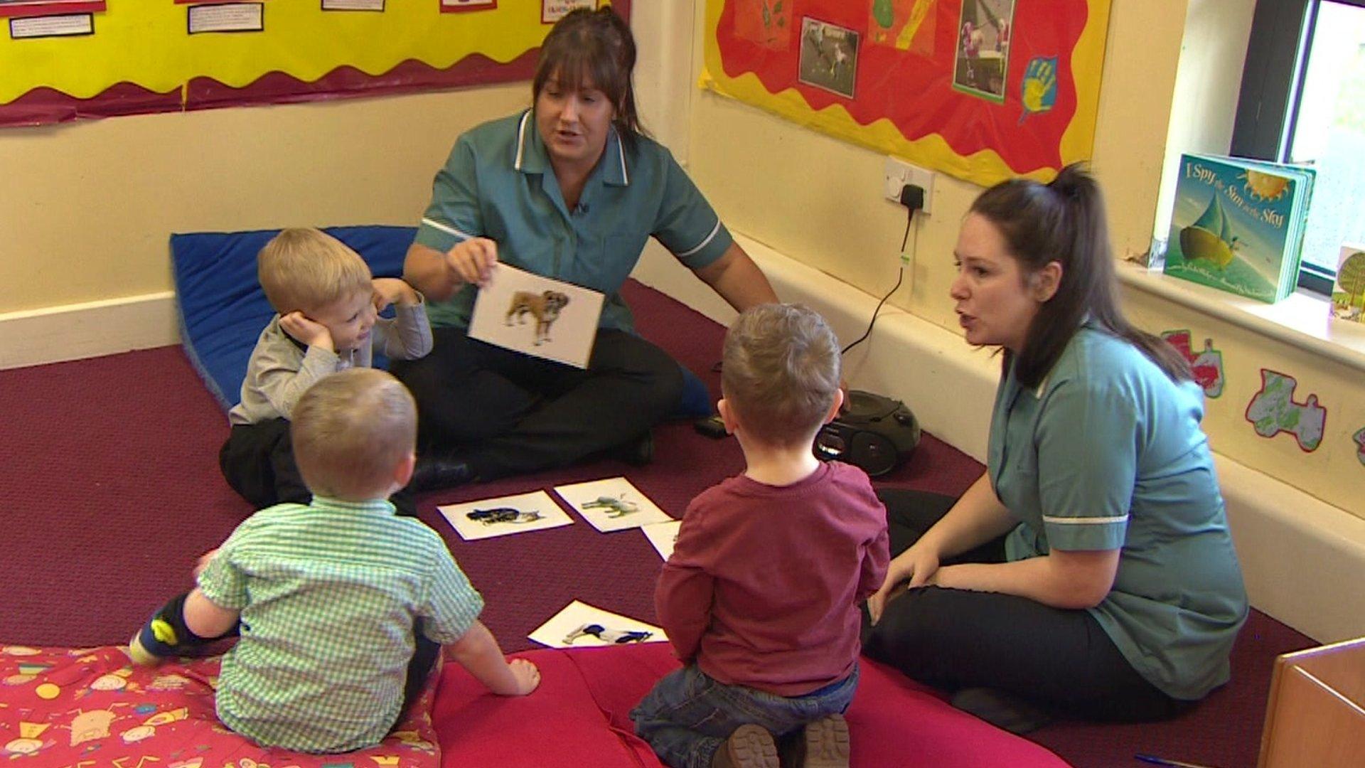 Nursery staff teaching two year olds