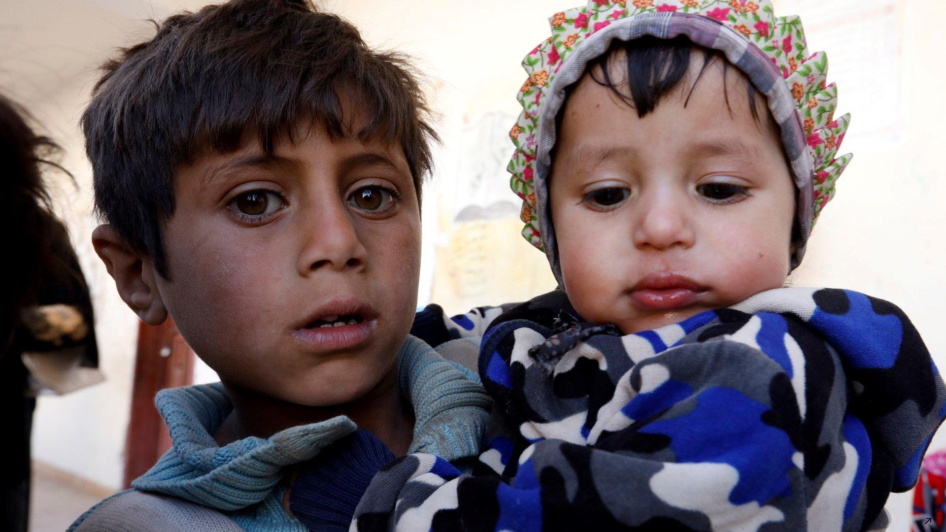 Children wait for food aid provided by a local humanitarian agency in Sanaa, Yemen (1 December 2021)