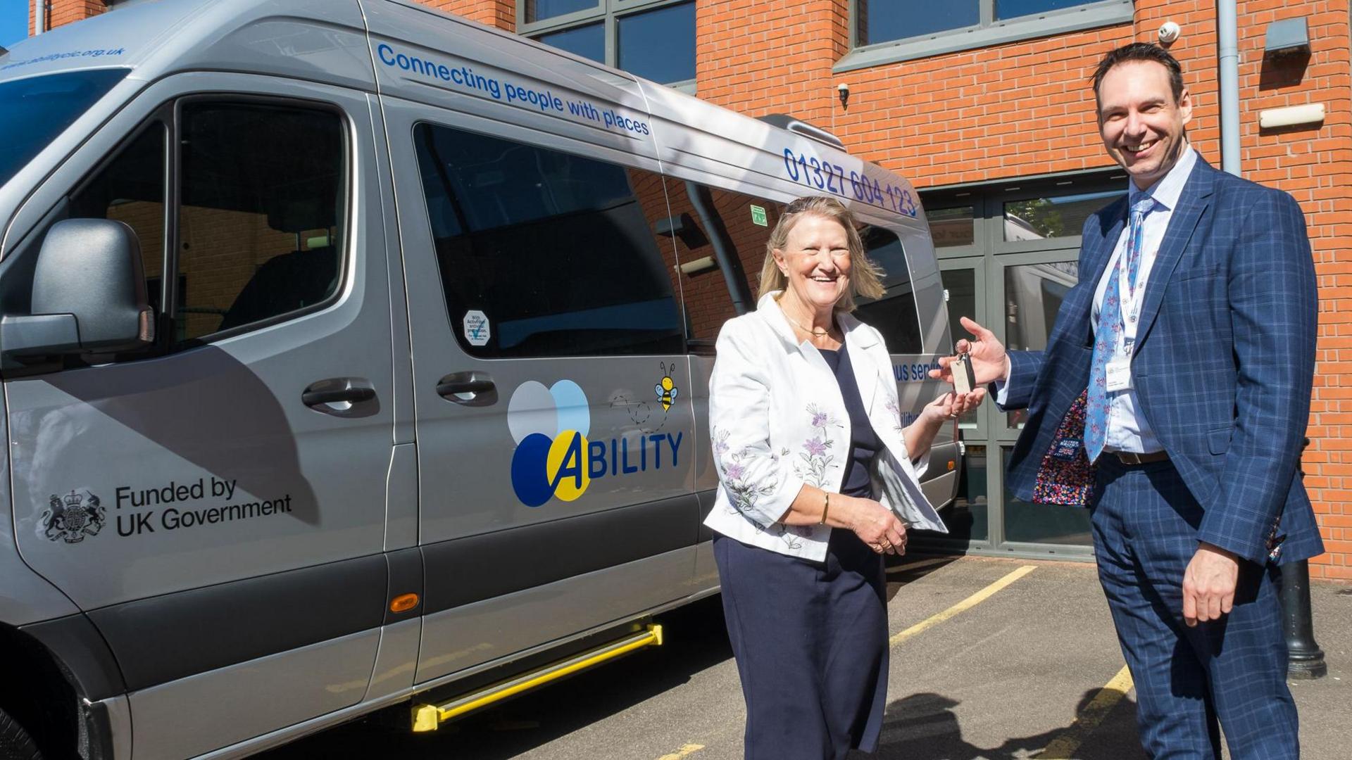 Lynn Hinch from Ability and councillor Dan Lister pose next to an Ability-branded bus