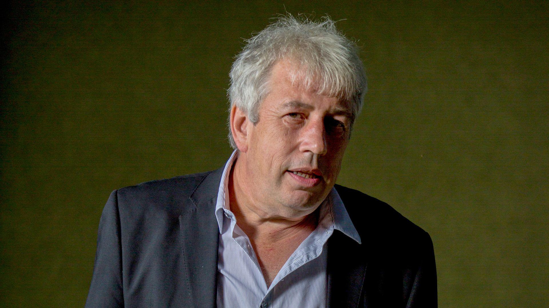 Rod Liddle looking up to his right, wearing a blue-striped shirt and navy jacket