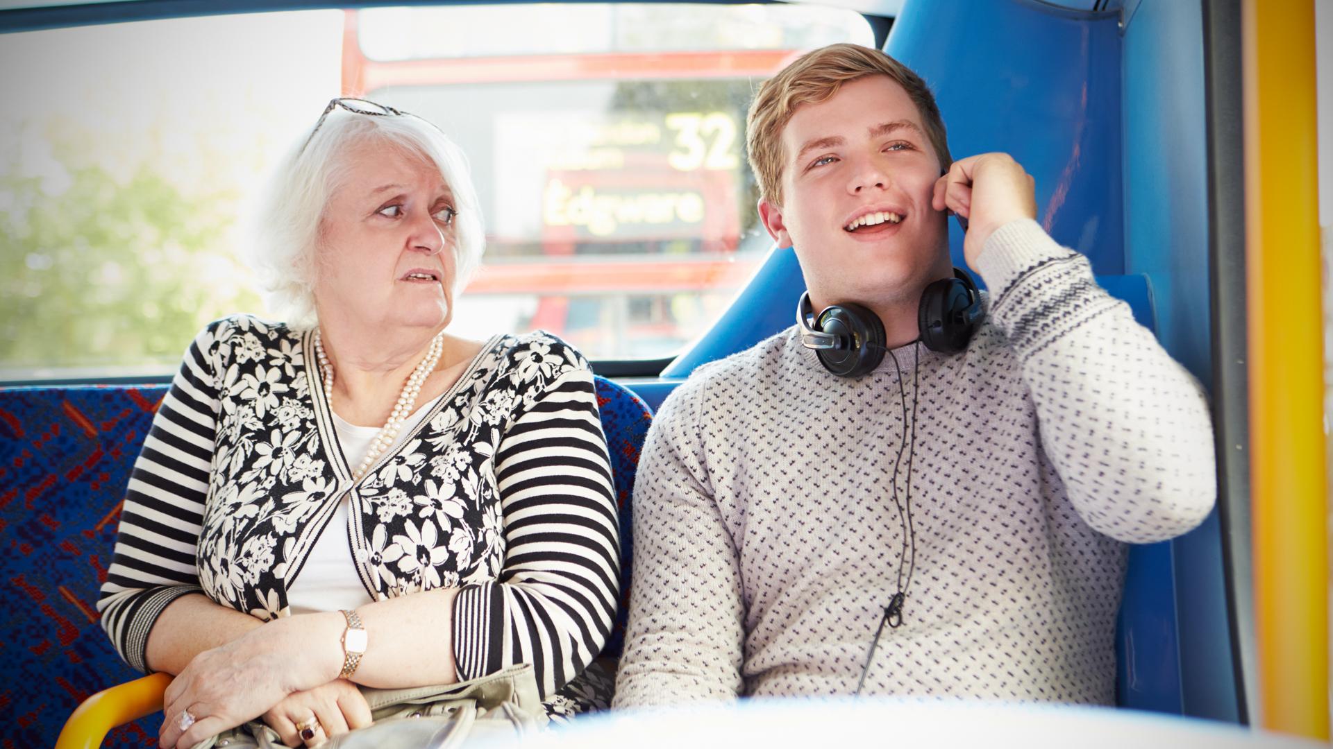 Woman looks annoyed at man sitting next to her