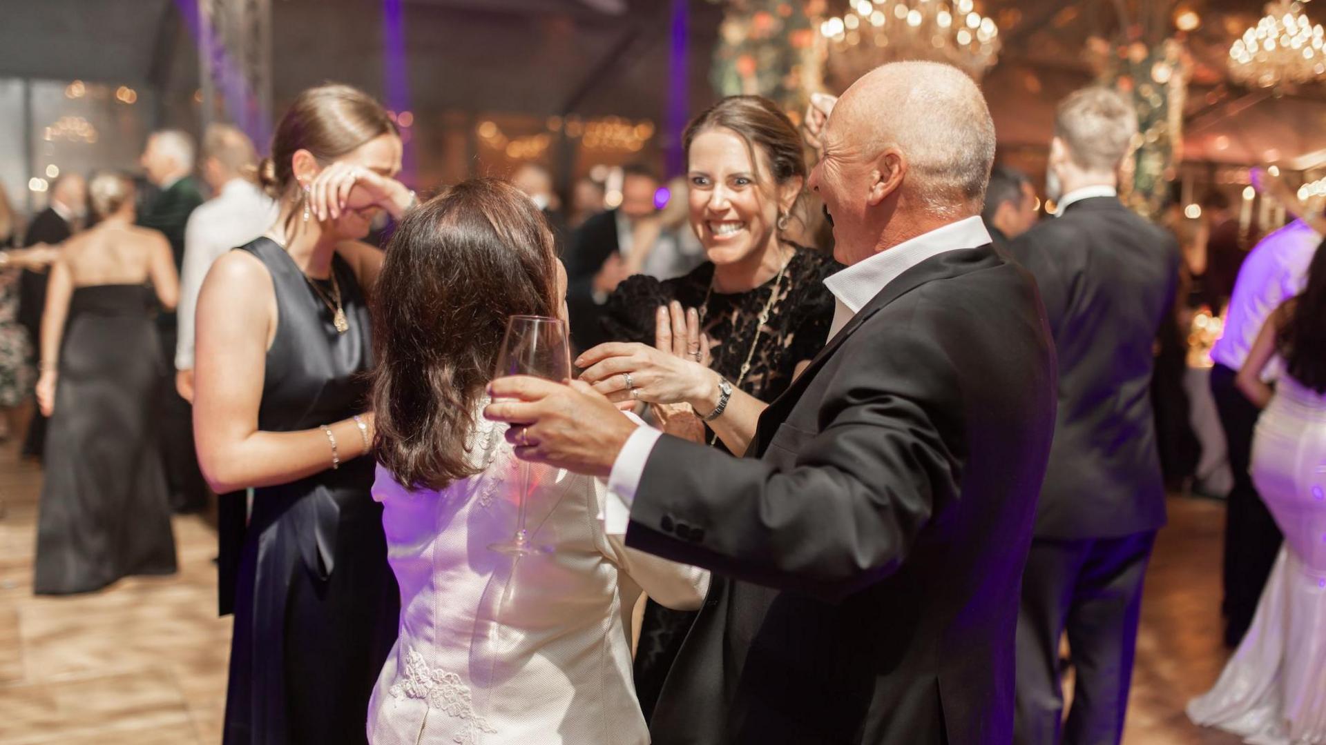 Guests at a charity gala night talk and laugh together