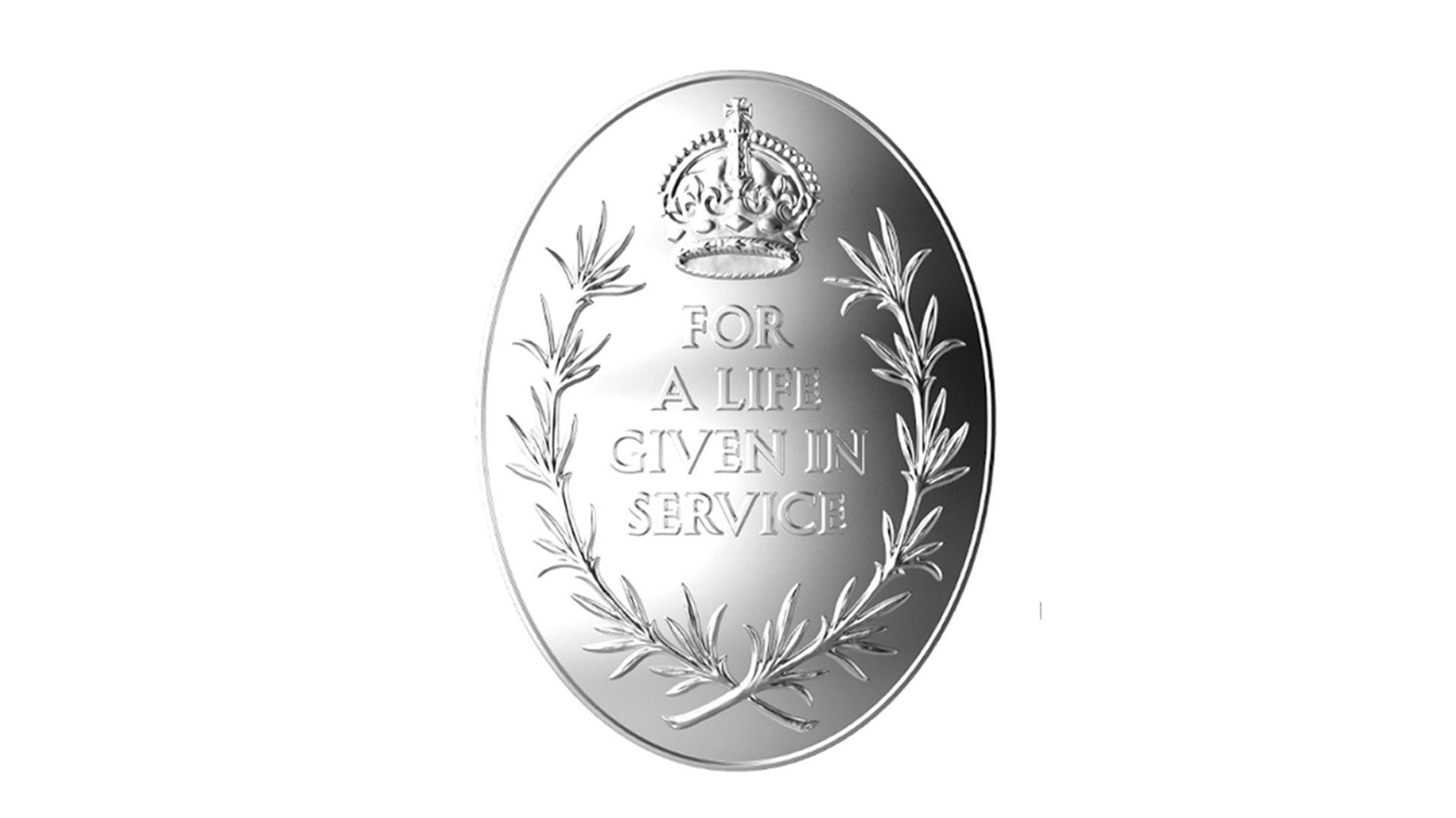 A silver medal, oval shaped with the words 'for a live given in service' engraved on it. 