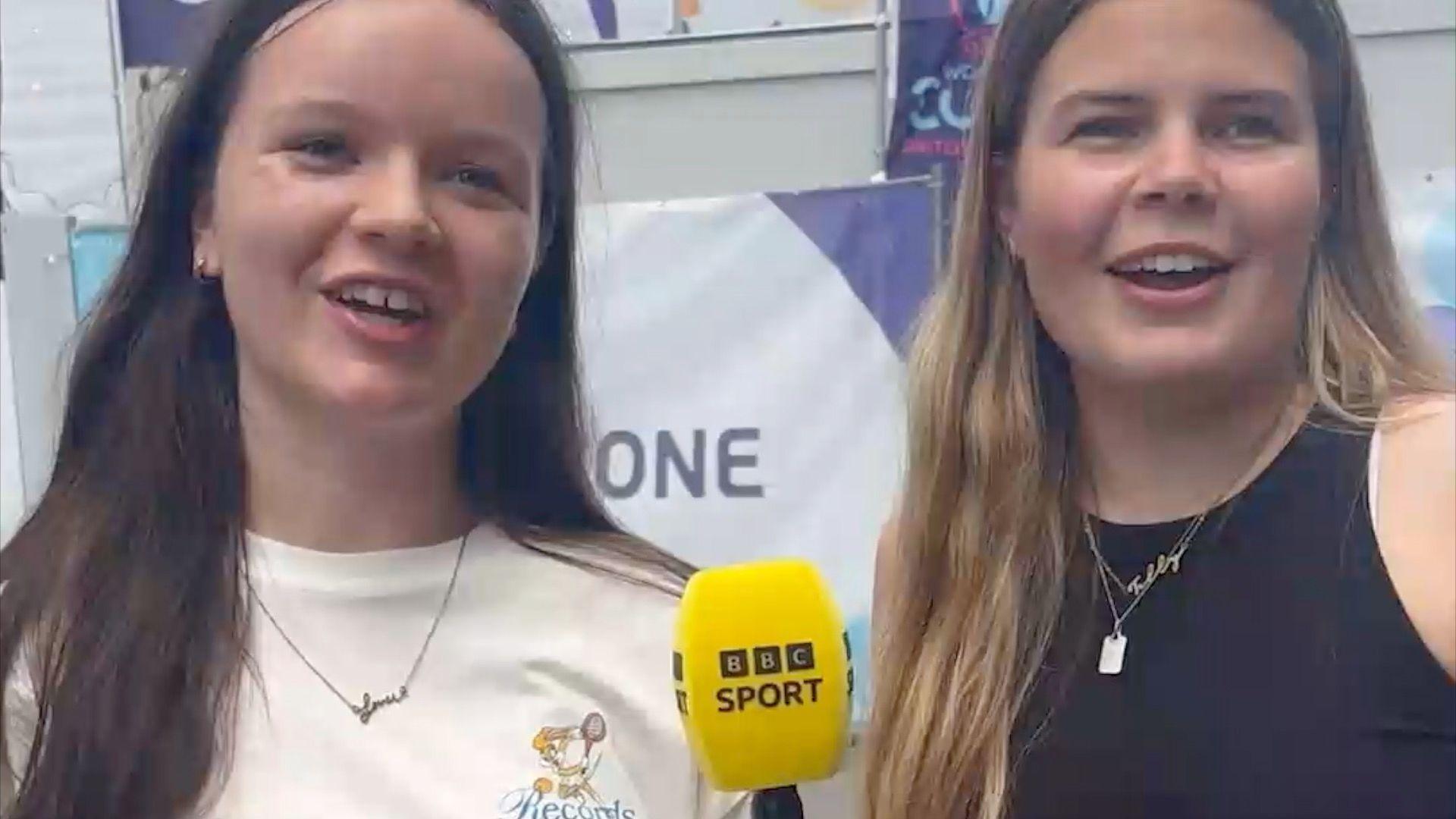 Two women looking into camera and holding BBC Sport-branded microphone
