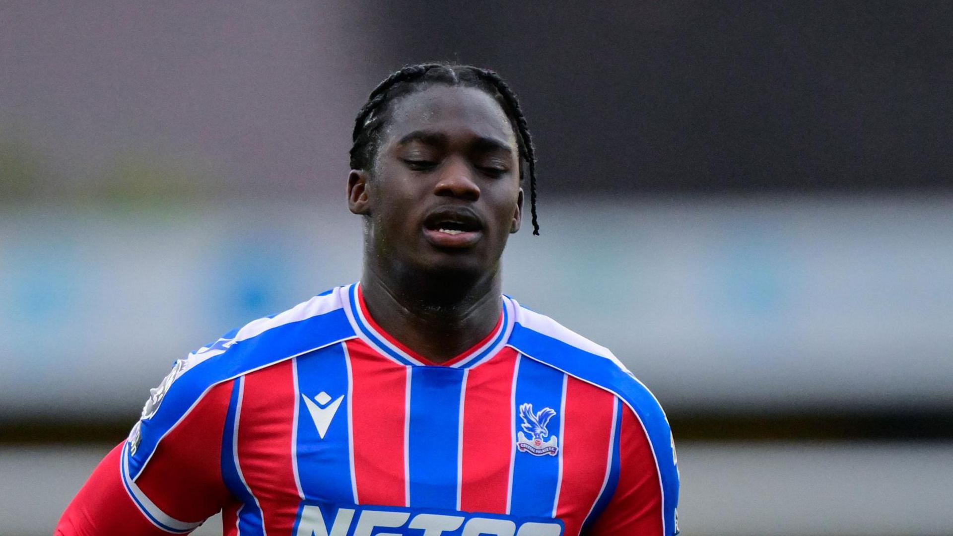 Hindolo Mustapha in a red and blue Crystal Palace jersey during a match
