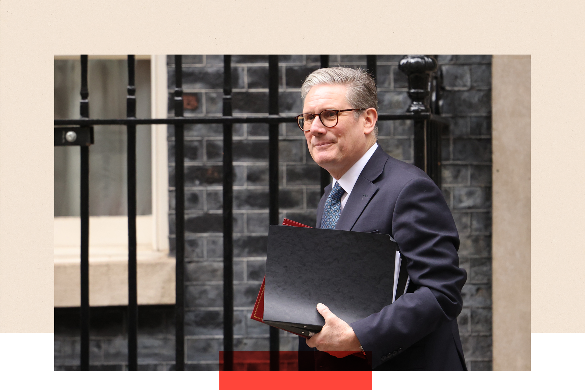 Keir Starmer carrying documents as he walks.