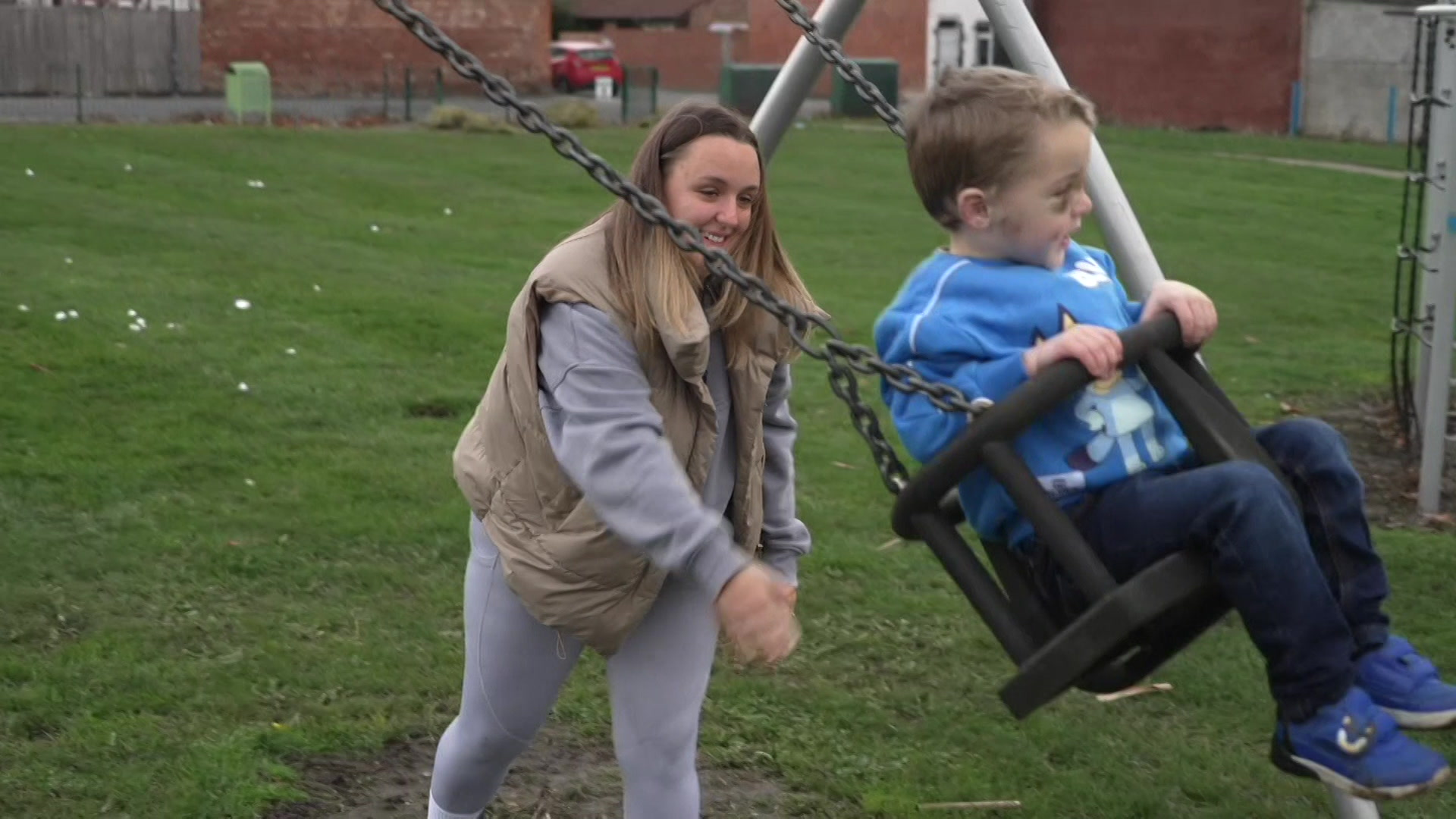 Joanne is pushing Roman who is on a swing in the park