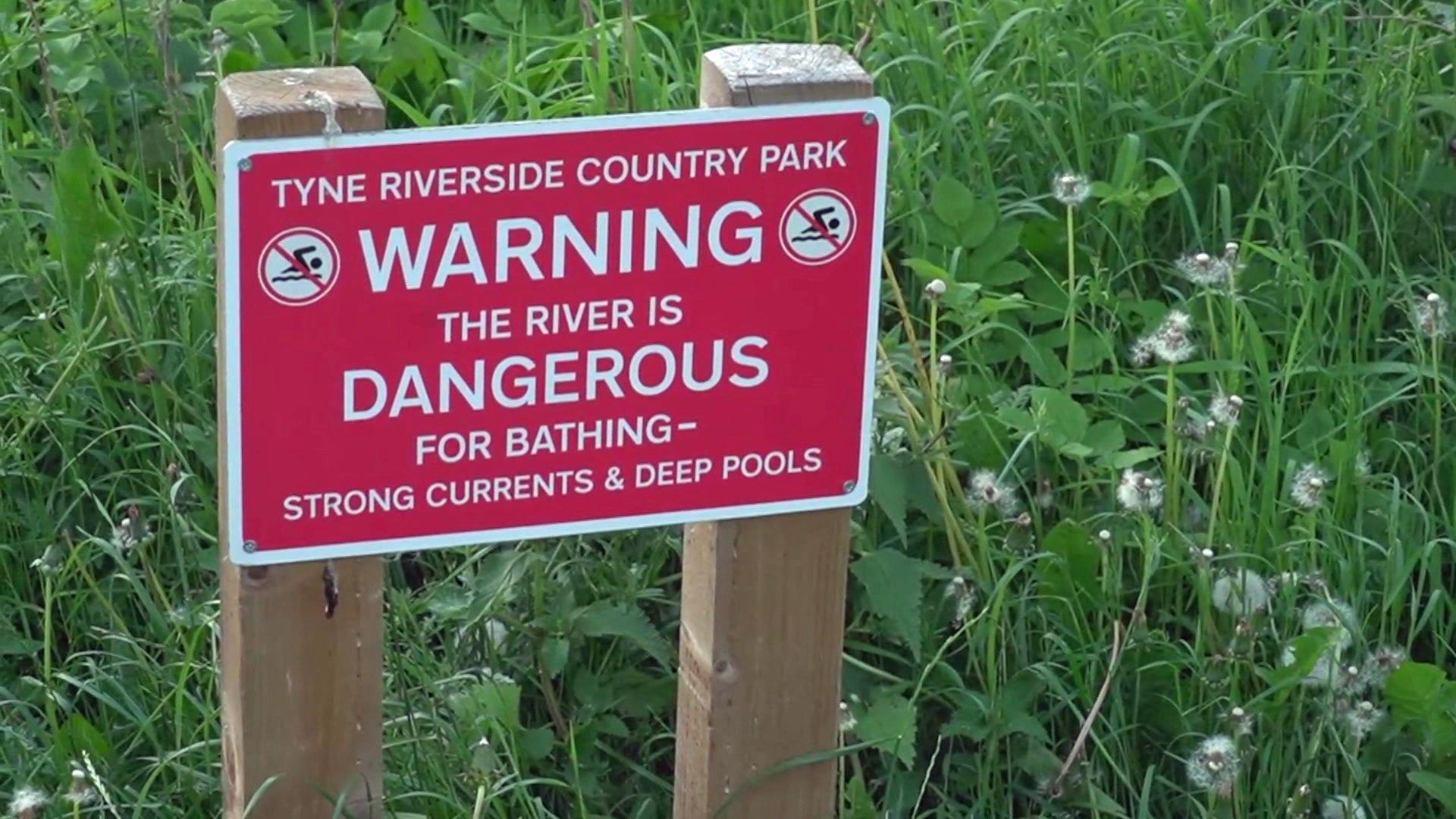 Sign saying: Warning the river is dangerous for bathing