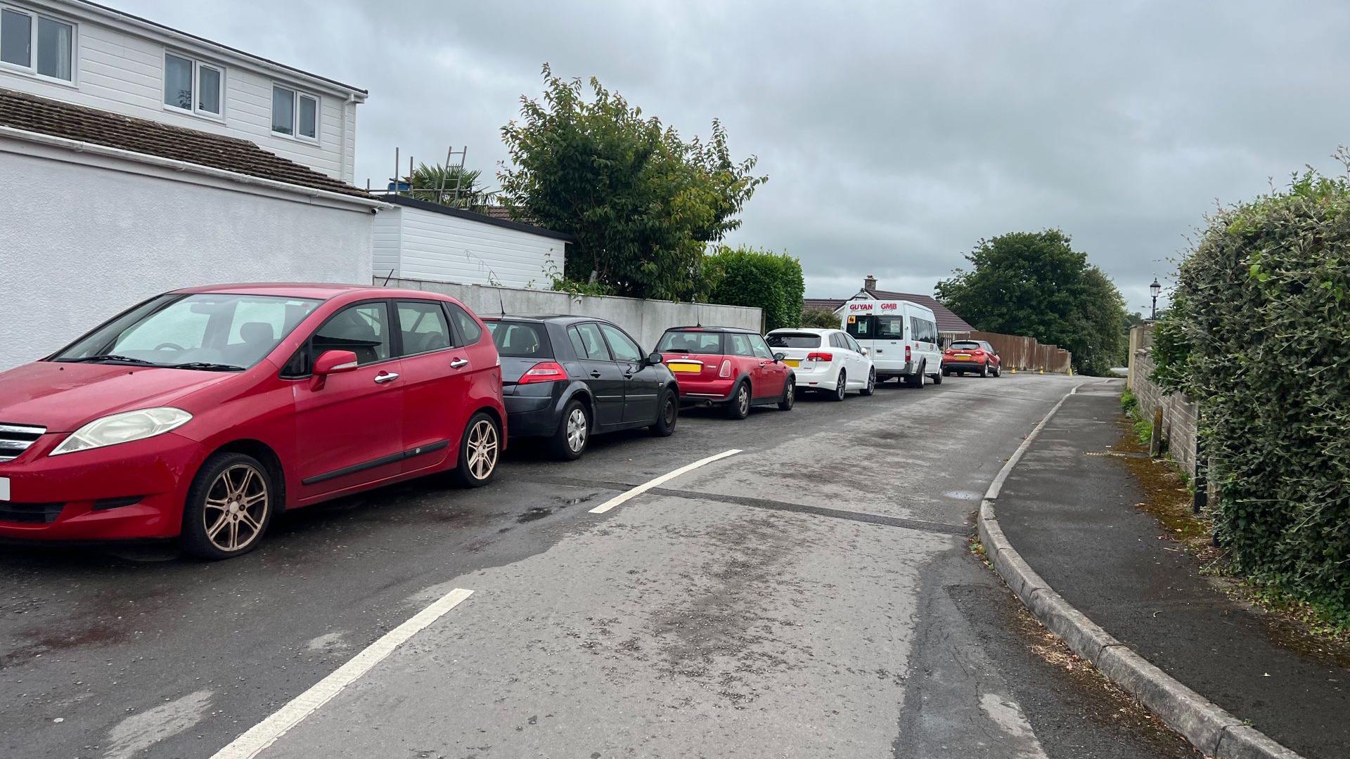 A row of six cars parked on a street