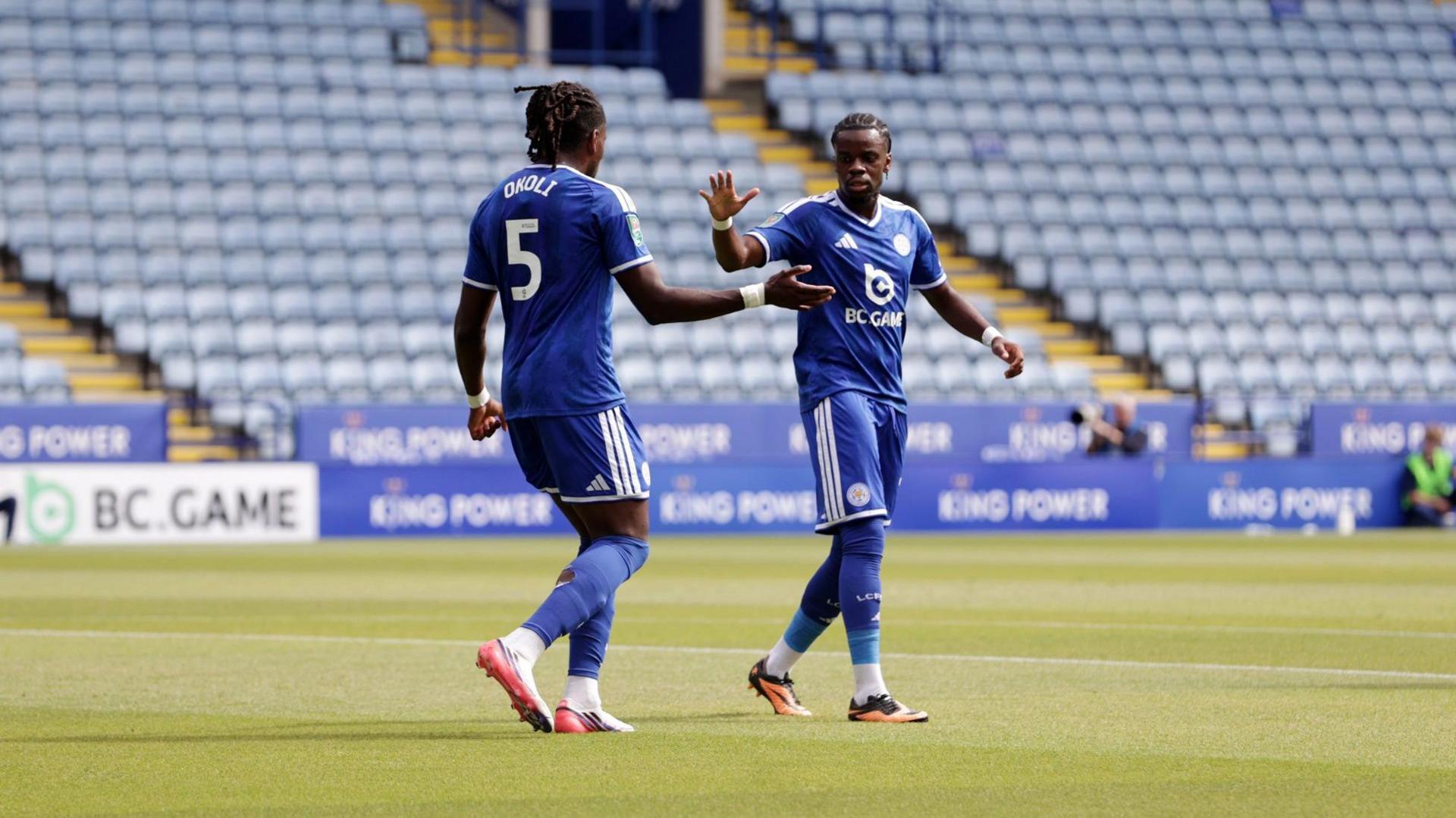 Caleb Okoli and Stephy Mavididi celebrate a goal in their Leicester City home kits during their EFL match against Northampton Town