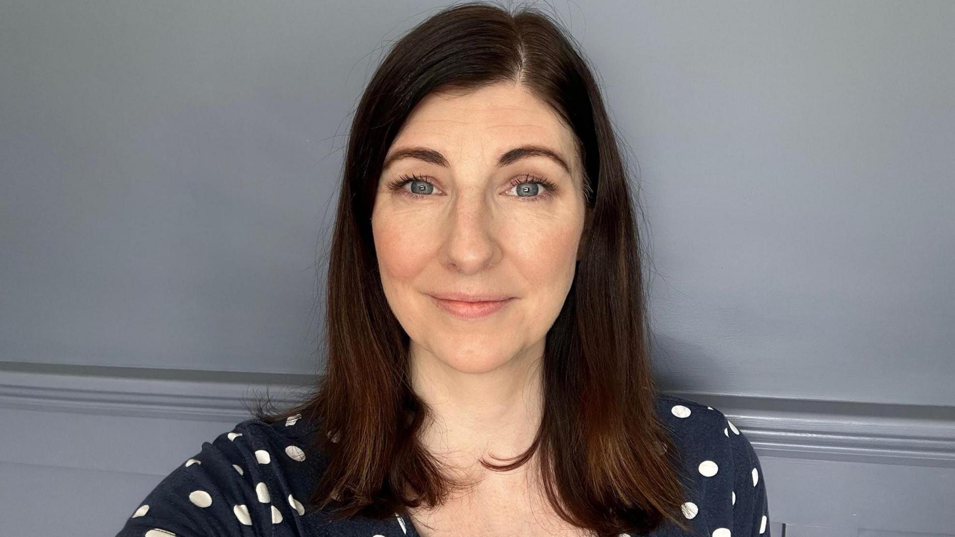 Louise Flanagan from the PHA looking directly at the camera, smiling and wearing a navy tshirt with white polka dots