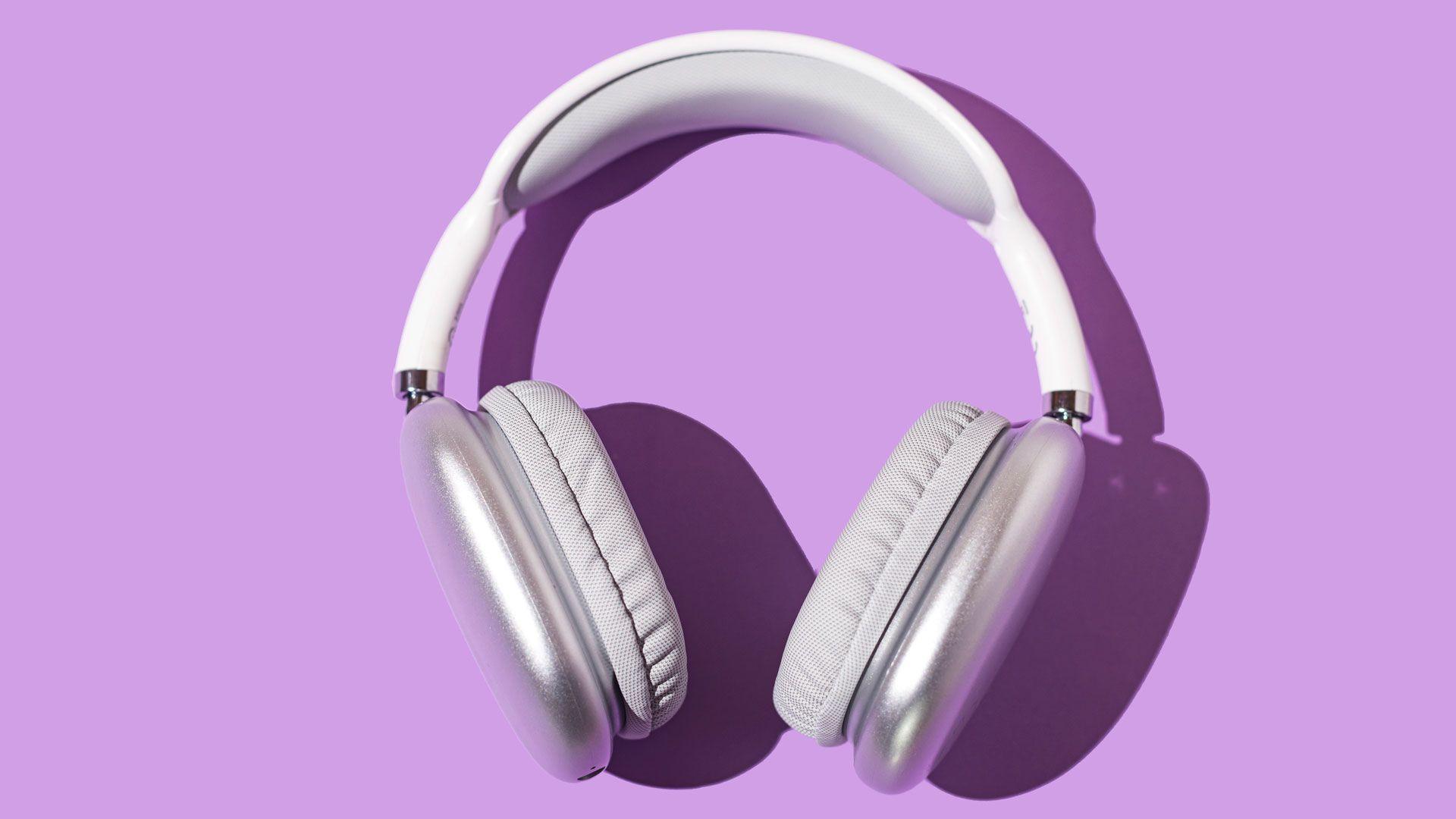 A pair of white headphones on a light purple background