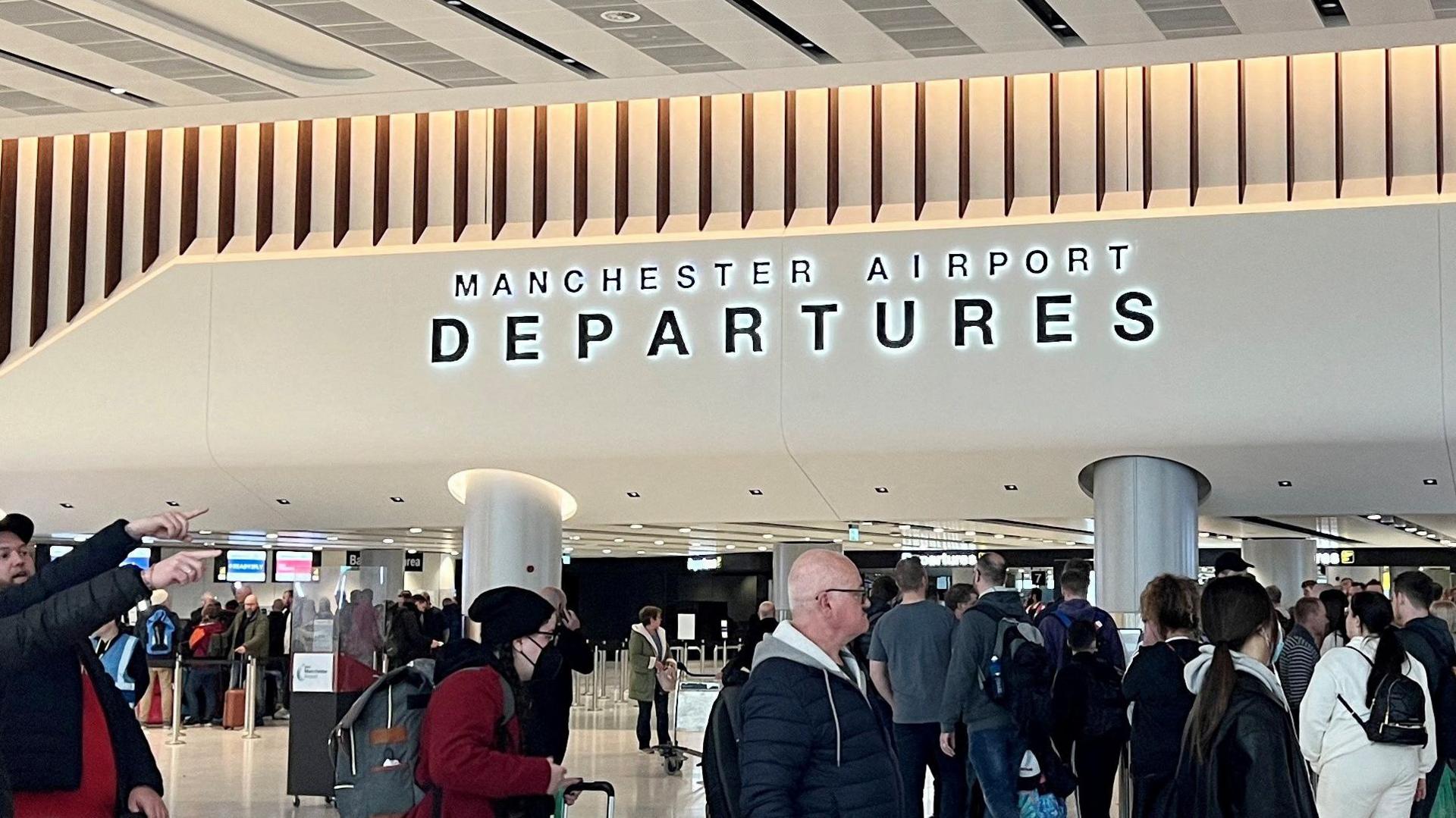 Passengers queue for security screening in the departures area of Terminal 2 at Manchester Airport