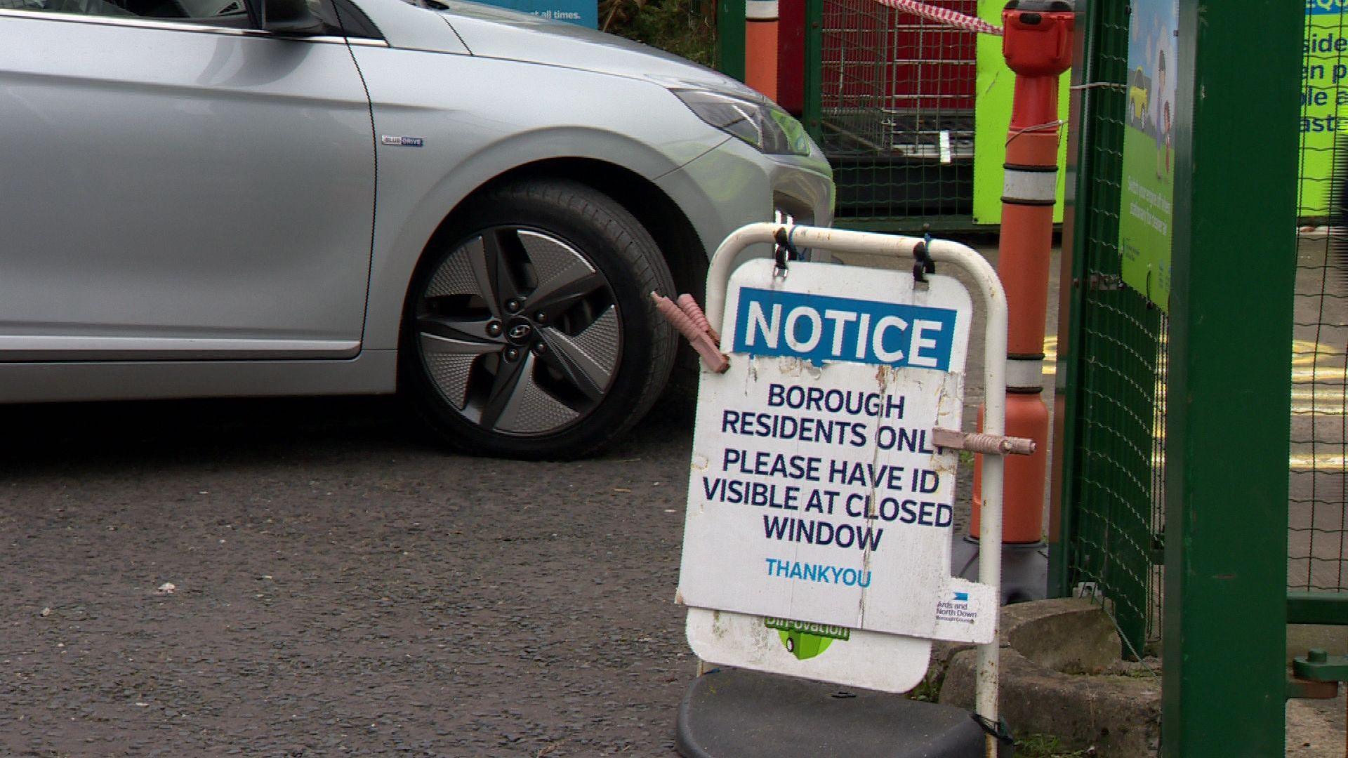 A notice saying "borough residents only" at a recycling centre at Holywood in the Ards and North Down council area. Behind it the nose of a silver car car can be seen driving towards a green gate at the entrance of the centre