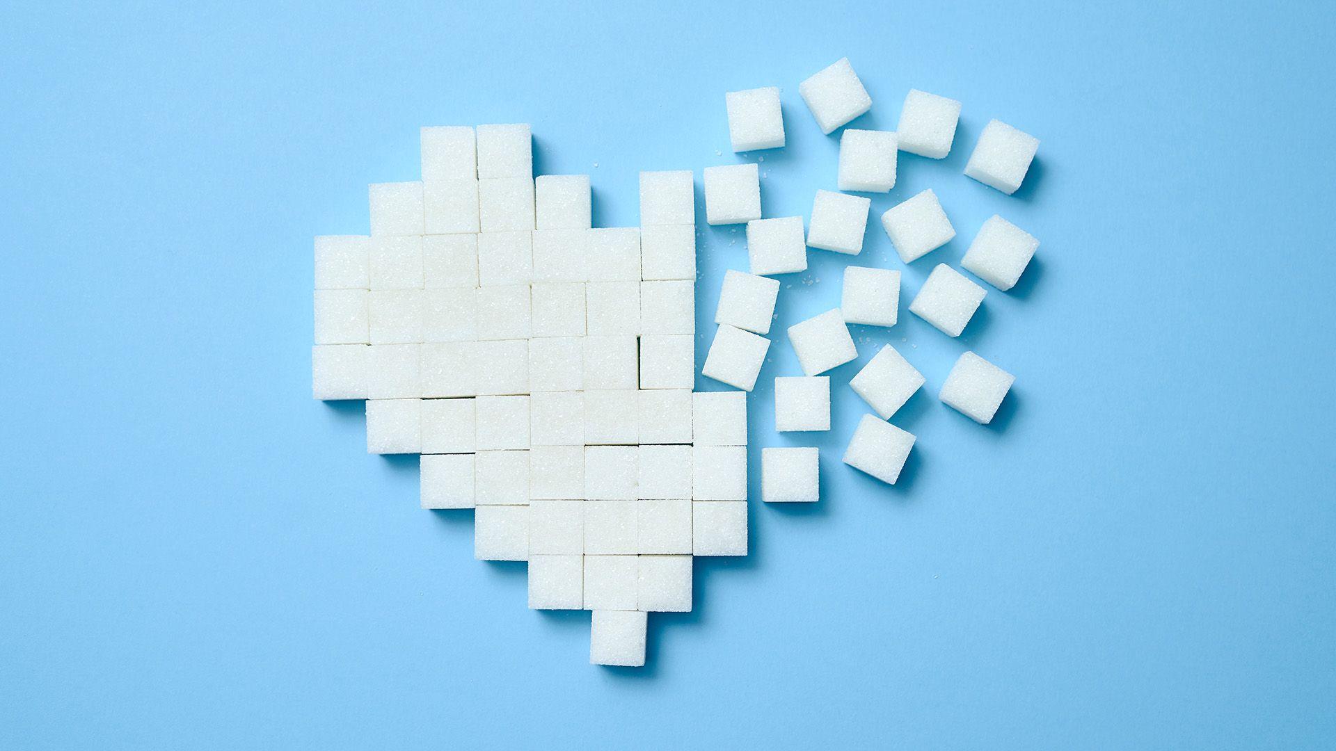 Sugar cubes arranged into a heart shape on a light blue background