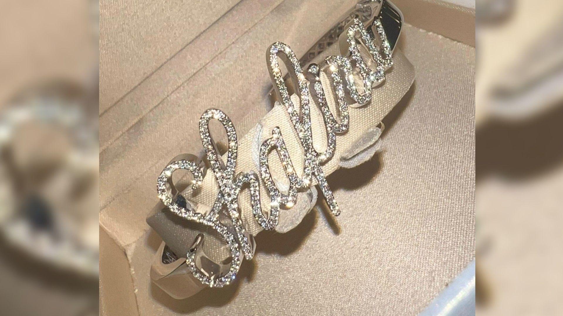 A bracelet that appears to be diamond encrusted, spelling the name Shafira