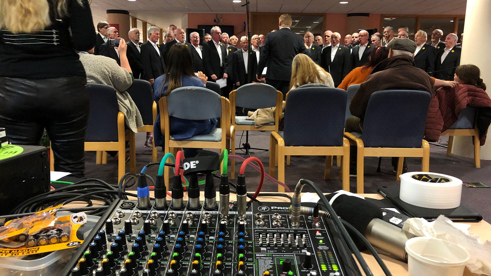 Peiriant recordio a chor yn y cefndir