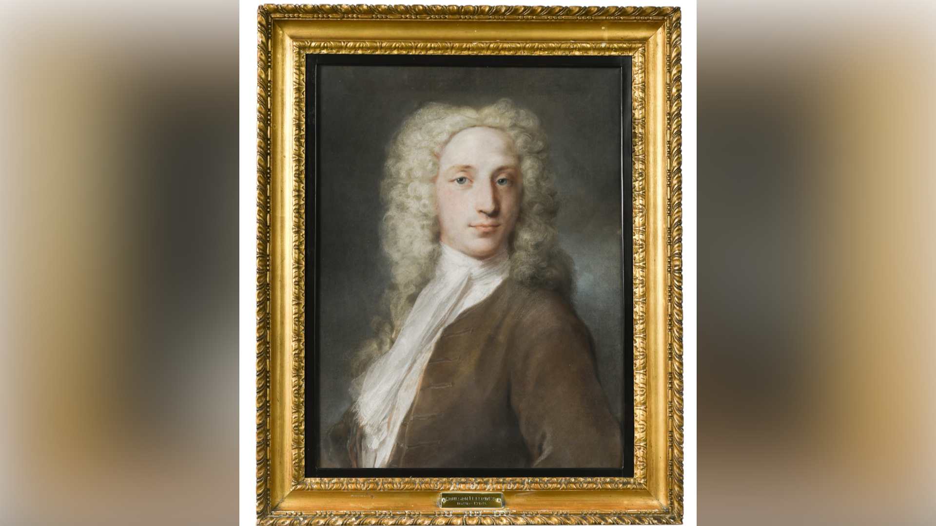 A portrait of a man dressed in an 18th Century manner, wearing a white wig, a scarf around his neck, a white shirt and a brown jacket. The painting sits within a gold coloured frame.