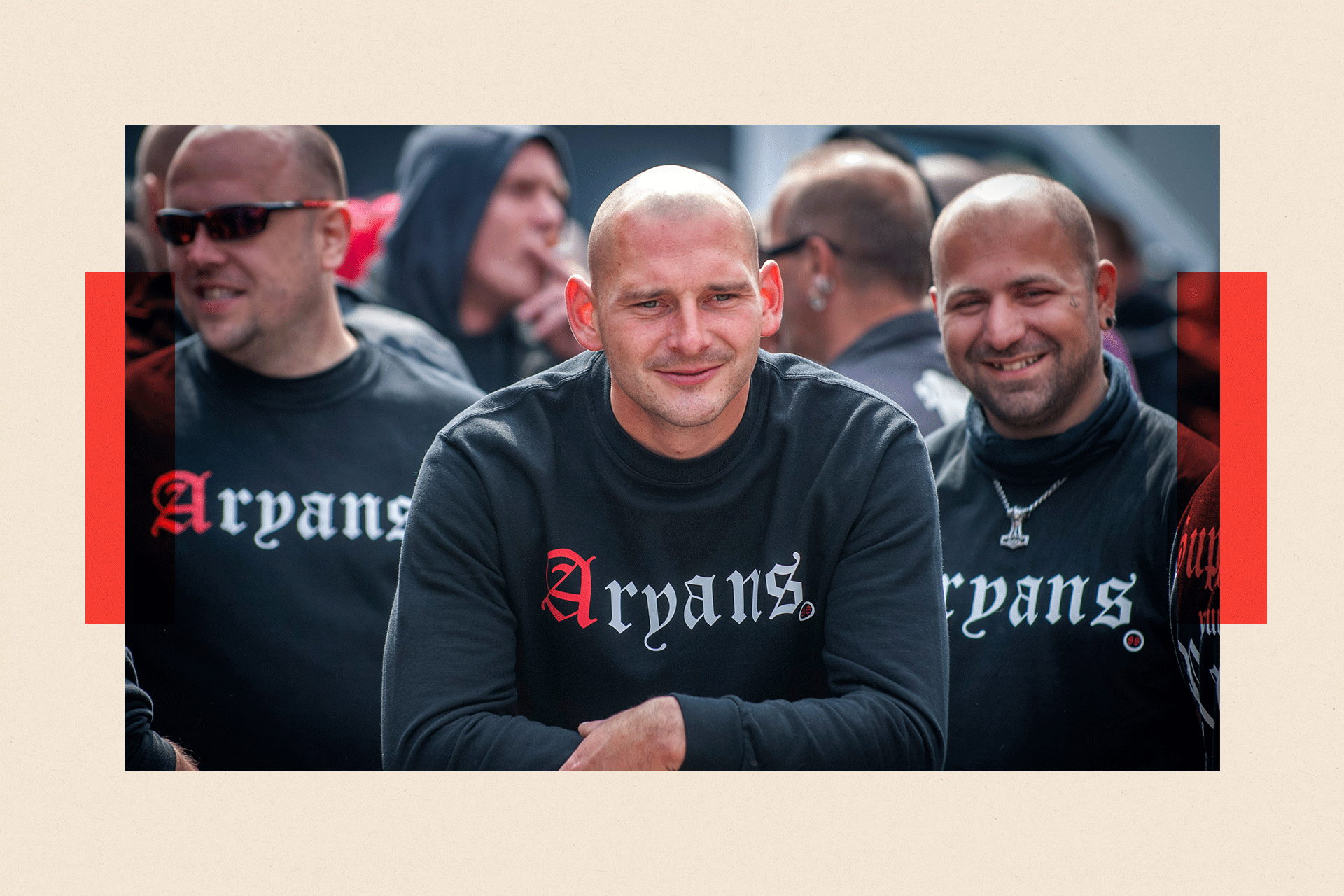 Three men wearing black jumpers that say "Aryans" on the front