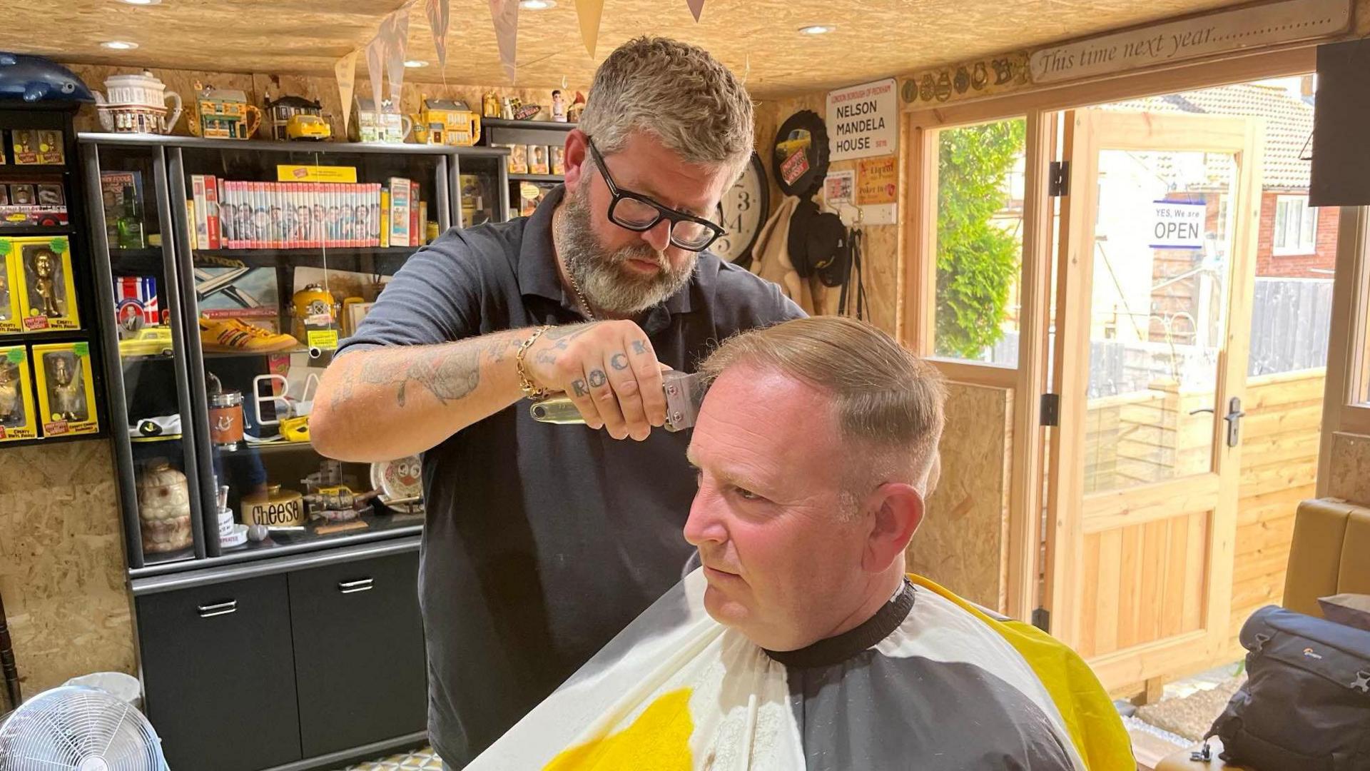 Nathan Scotford cuts Mike Parkinson's hair