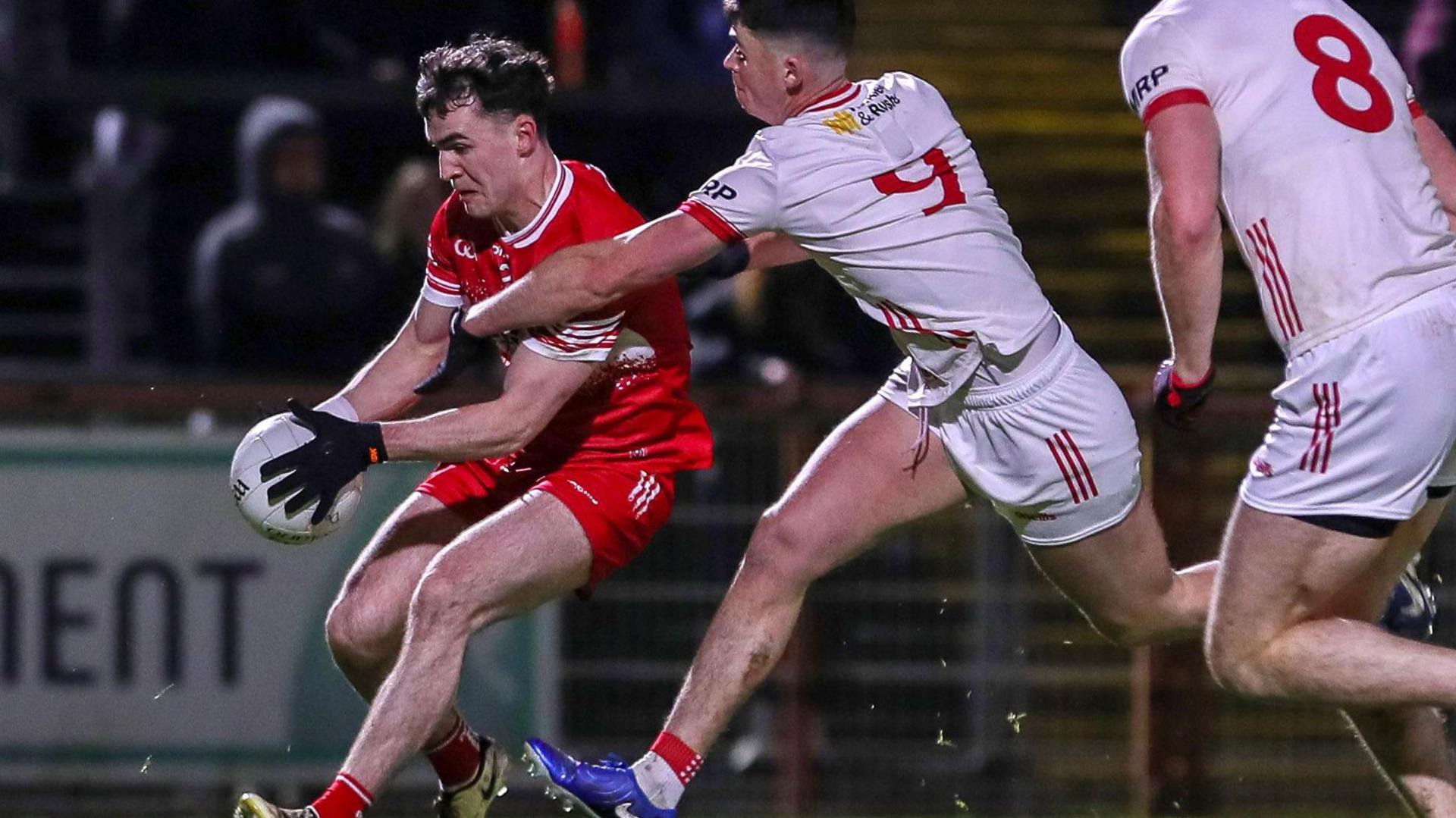 Derry defender Diarmuid Baker is followed by Liam Gray and Brian Kennedy of Tyrone in Healy Park