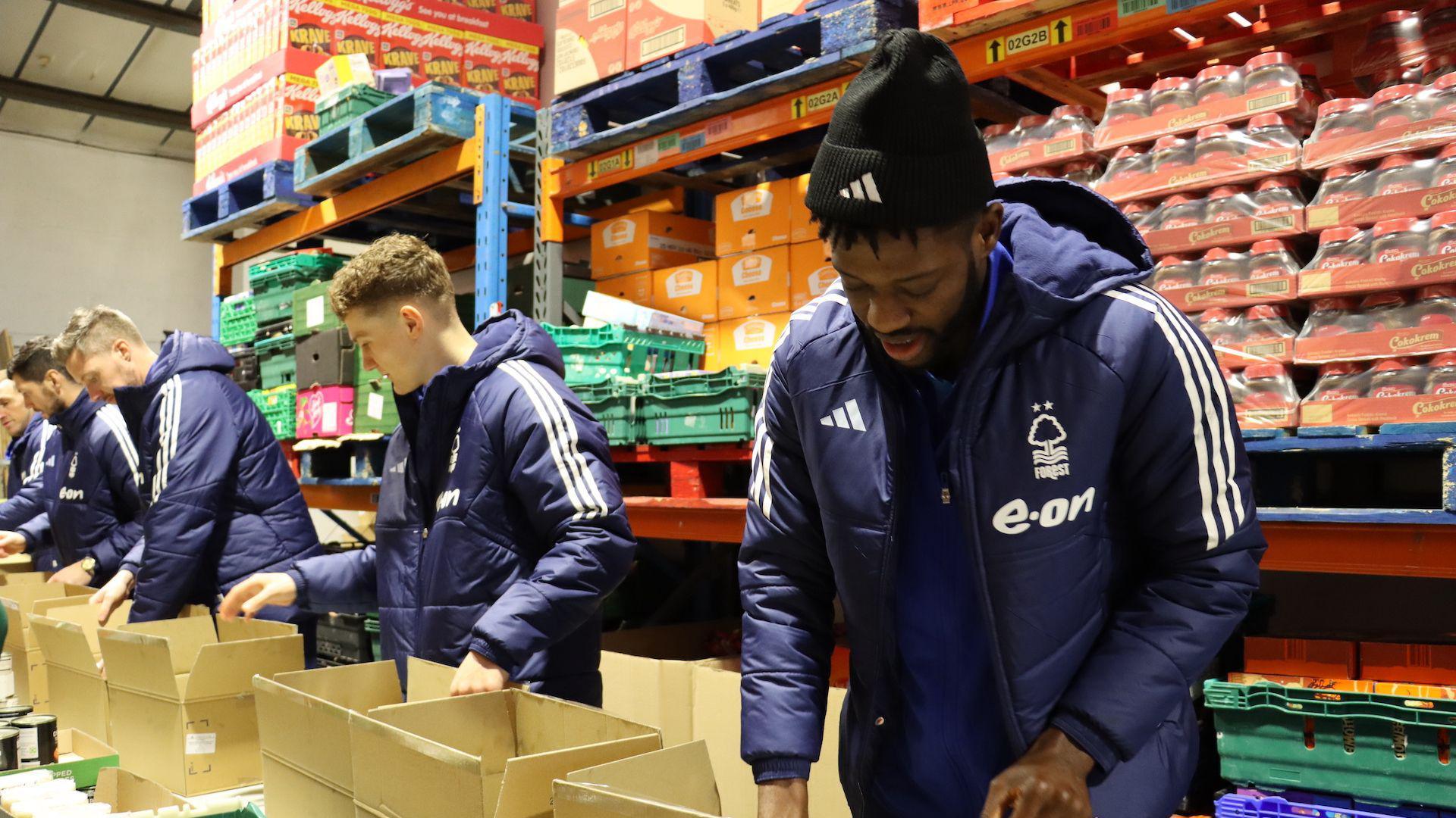 Nottingham Forest players help to package donated food into boxes as part of a drive to help struggling families across the city in 2023.