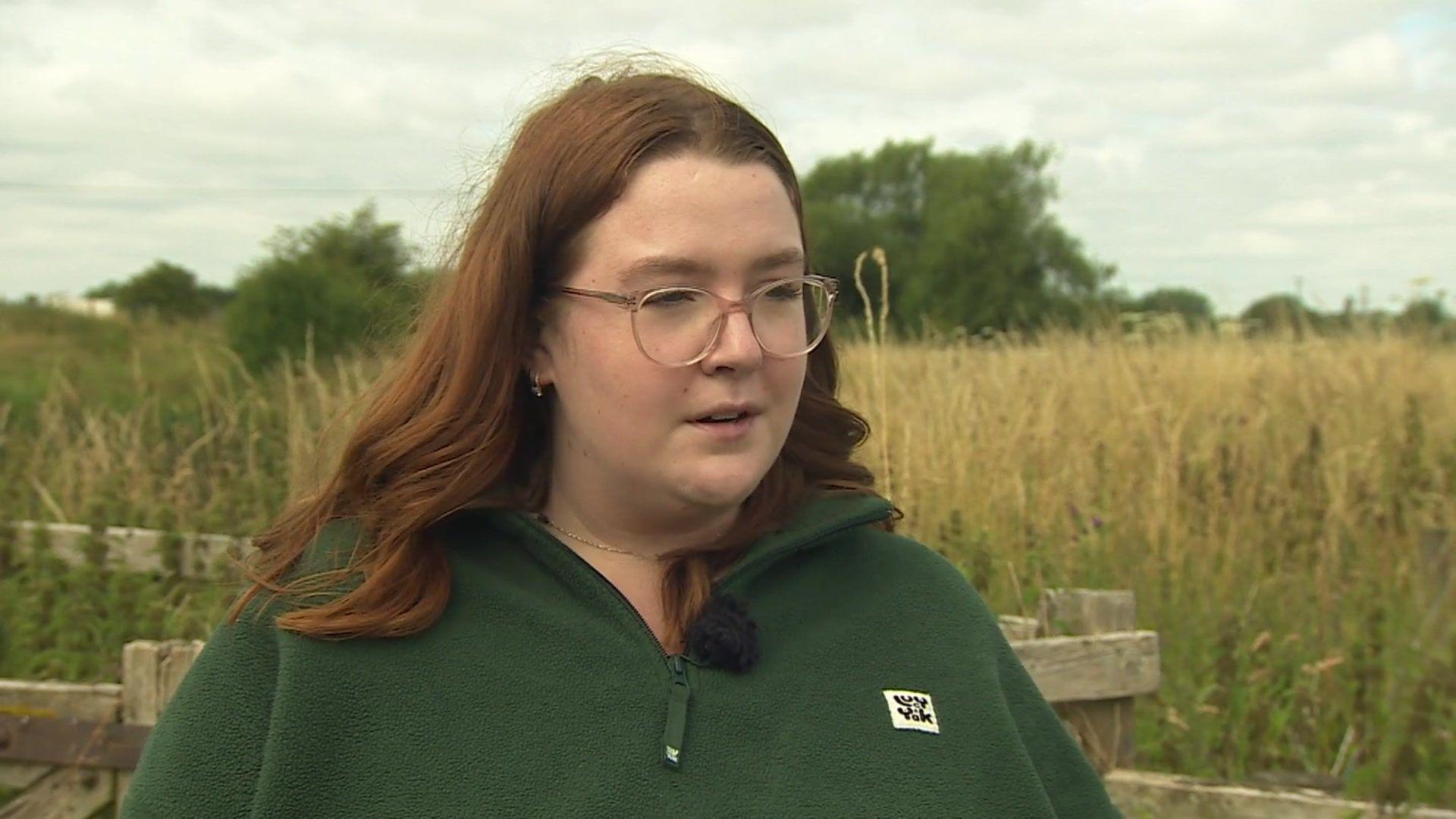 Natalie Duffus standing in front of a field of long grass