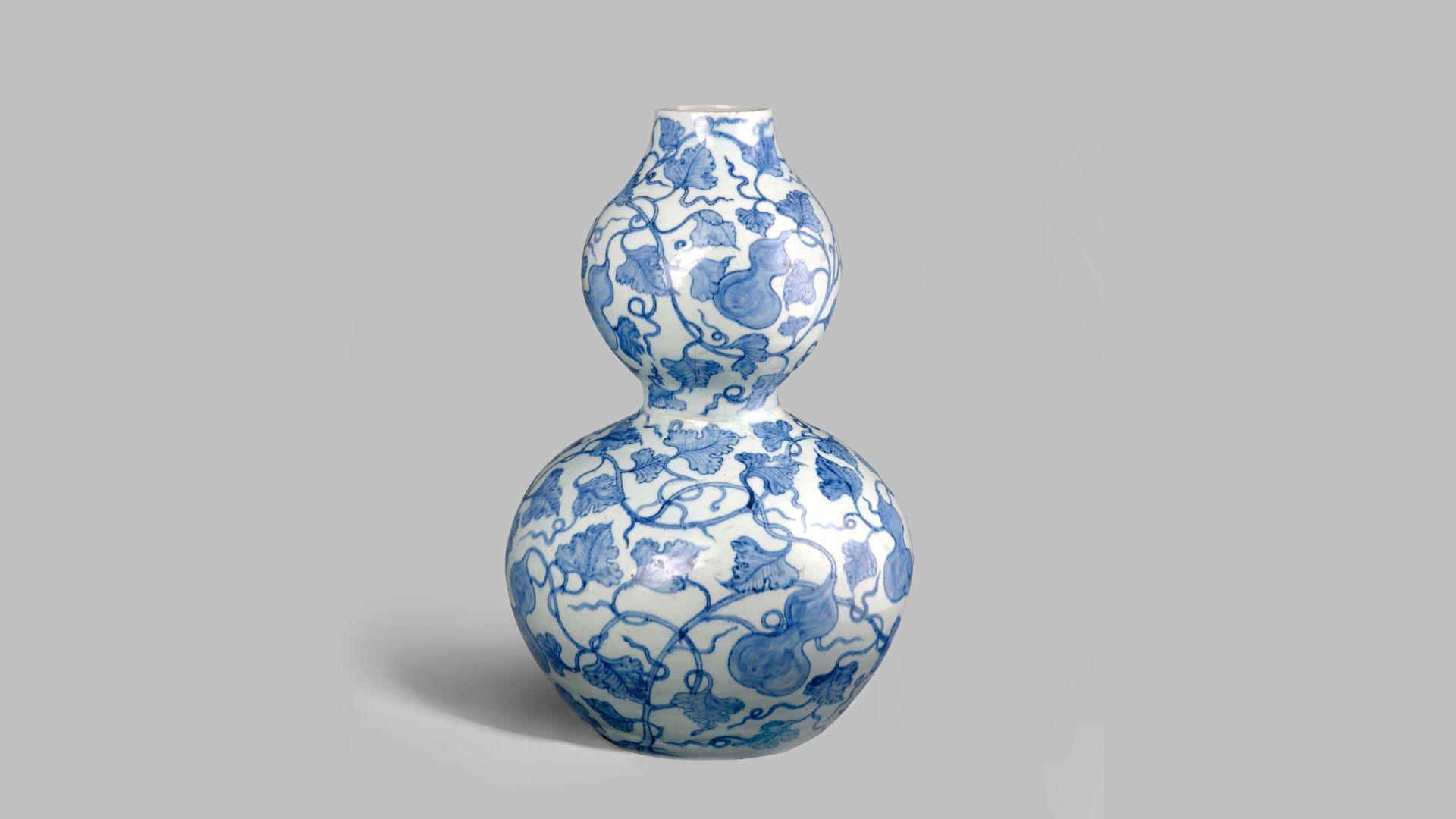 A Chinese vase from the Yuan Dynasty with blue plant motifs against a white background.