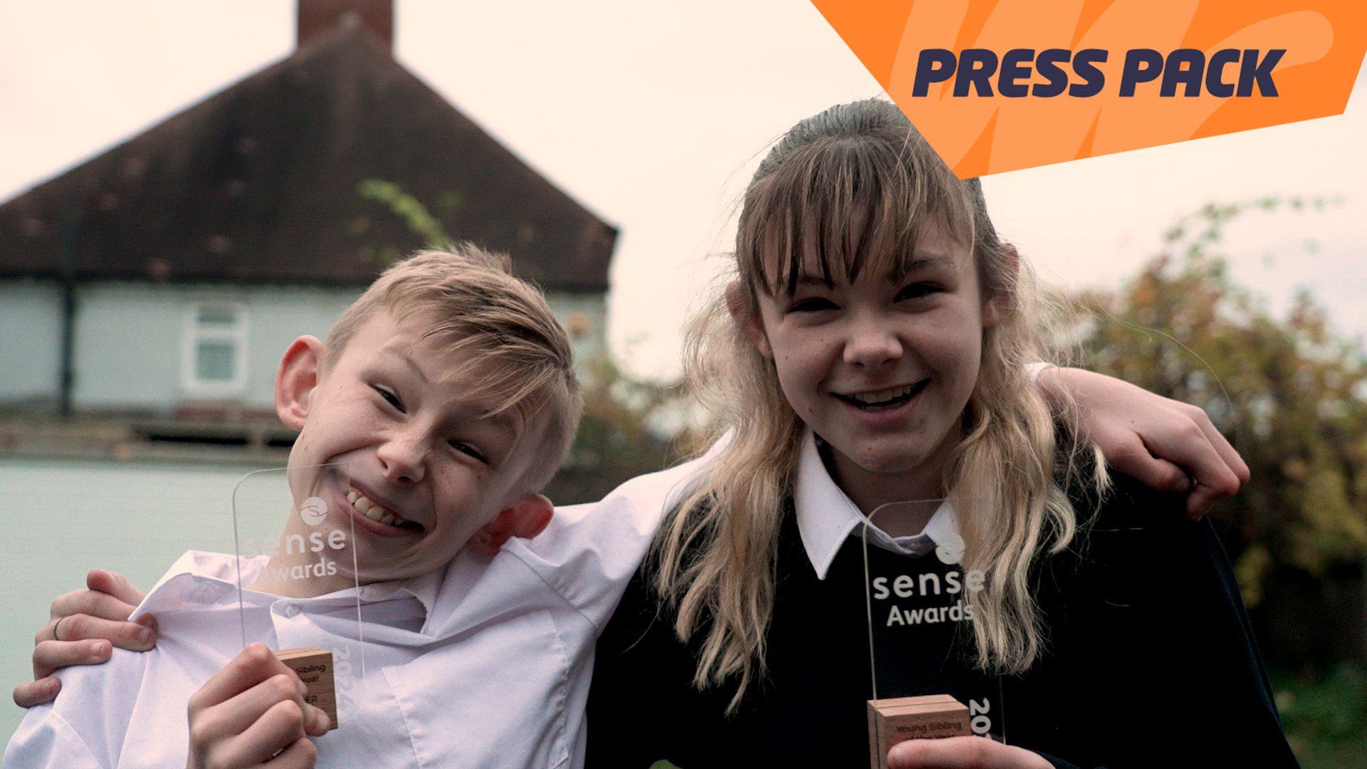 Freddie and Bayleigh smile as they hold their Sense Award.