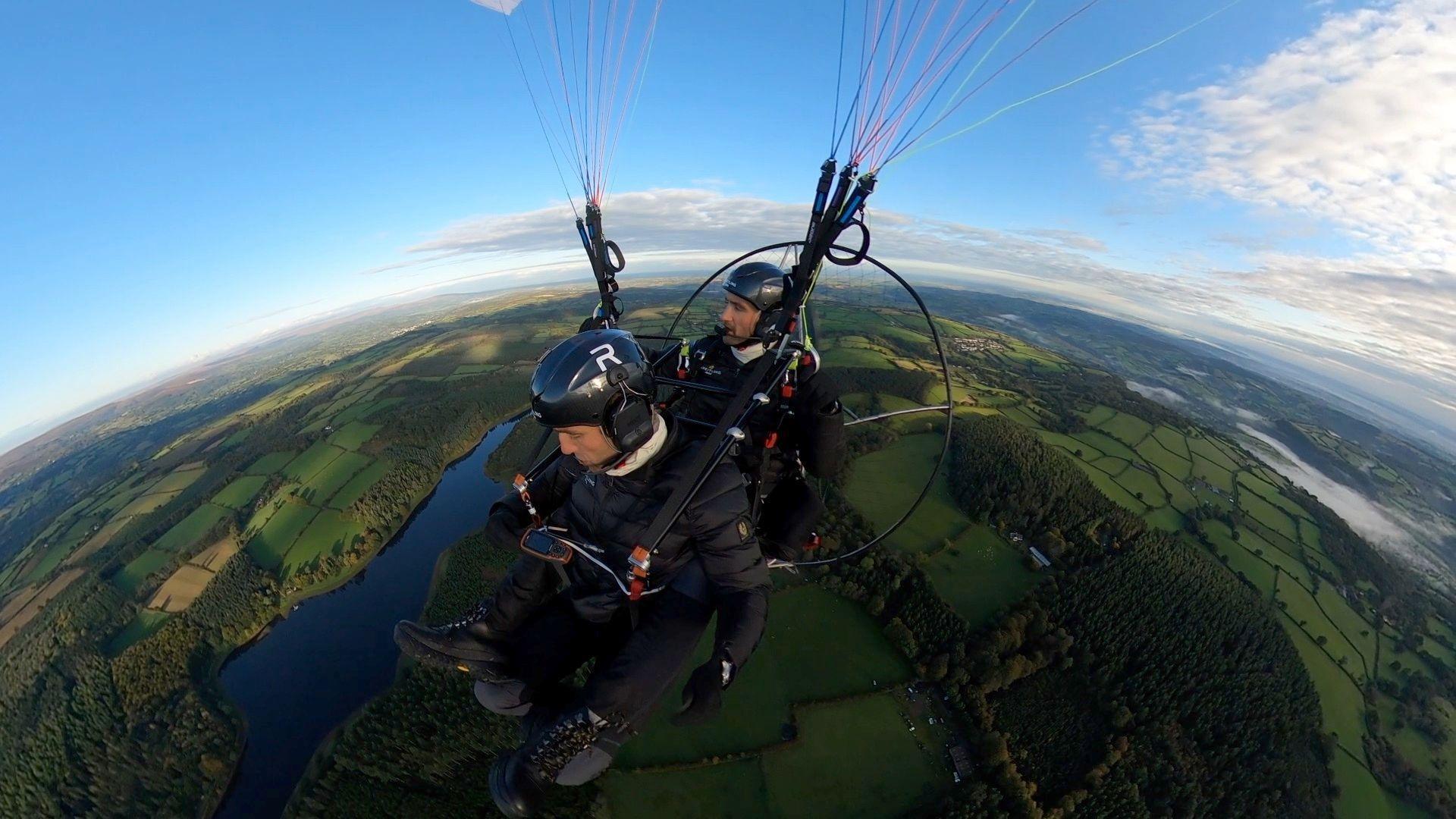 The Turner Twins flying a paramotor over Dartmoor. A paramotor is a powered paraglider, consisting of a harness and framework to hold the aviators and the engine of the aircraft, which is suspended from a parachute.