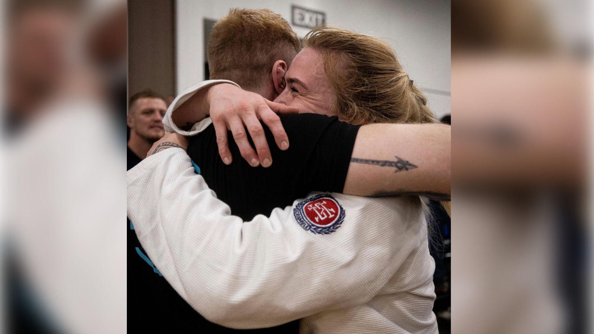 Mairead Rowland-Coman yn cofleidio'i phartner Bryn