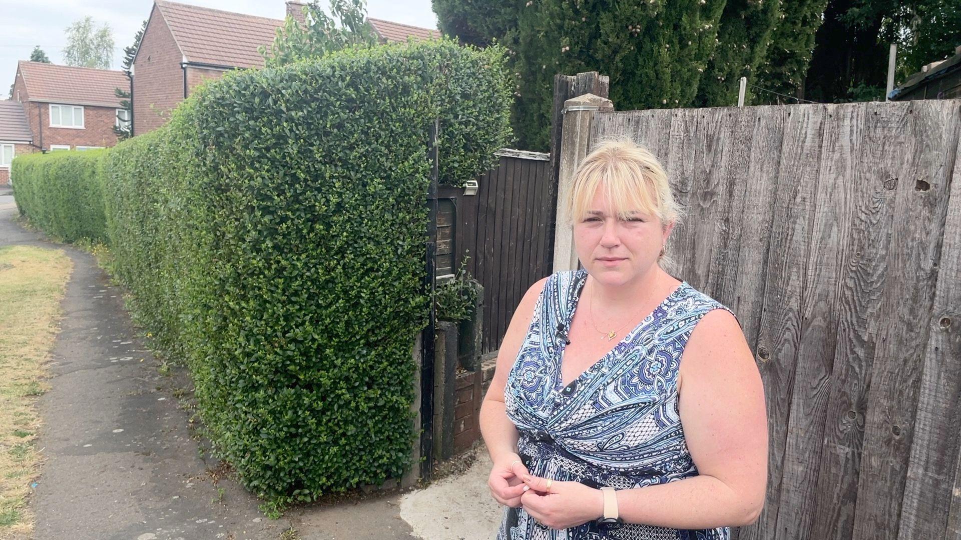 Anna Gilkinson standing on a pavement next to her back gate