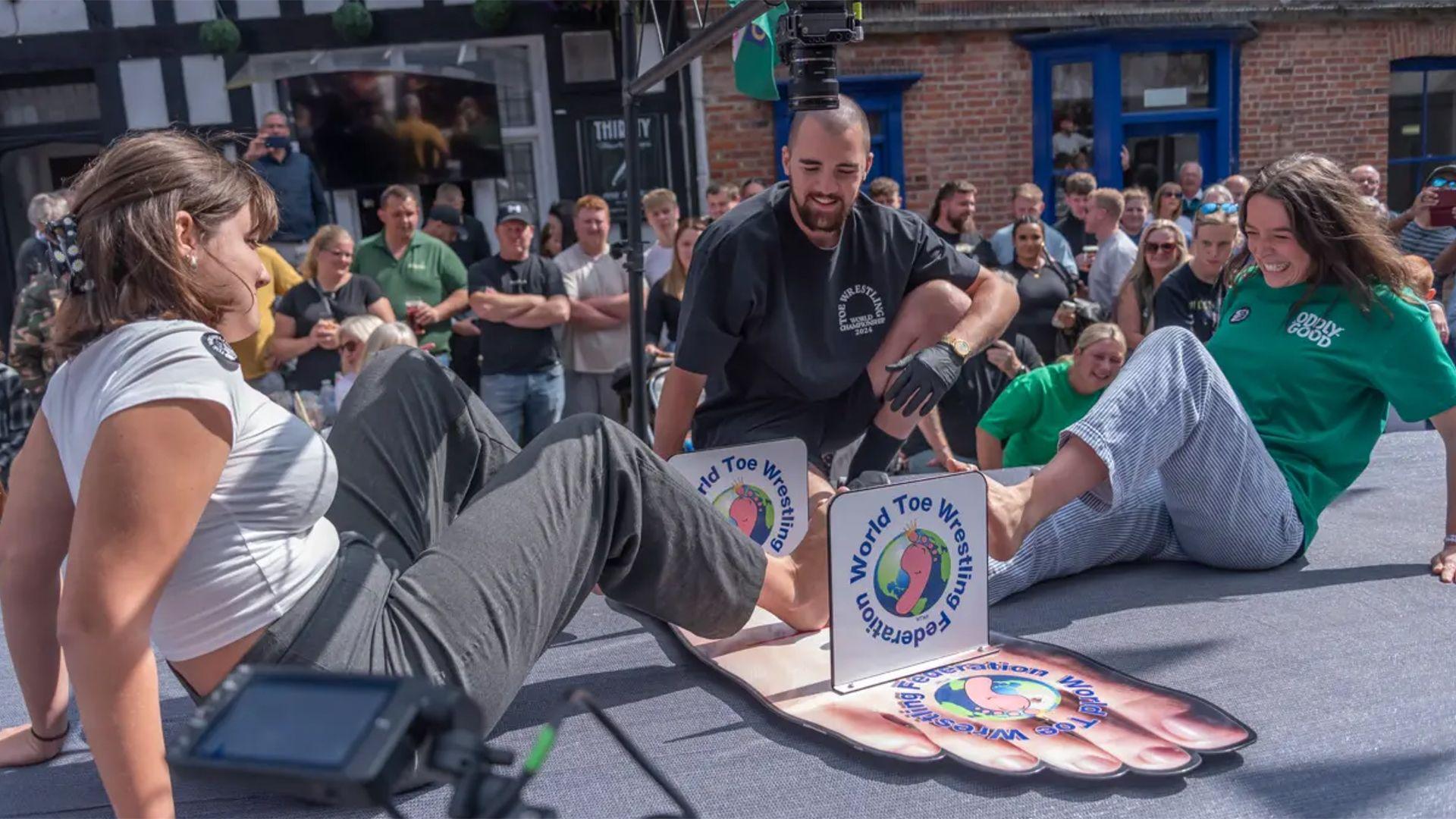 Two women locking their feet together competing in the annual World Toe Wrestling Championship in Fenny Bentley