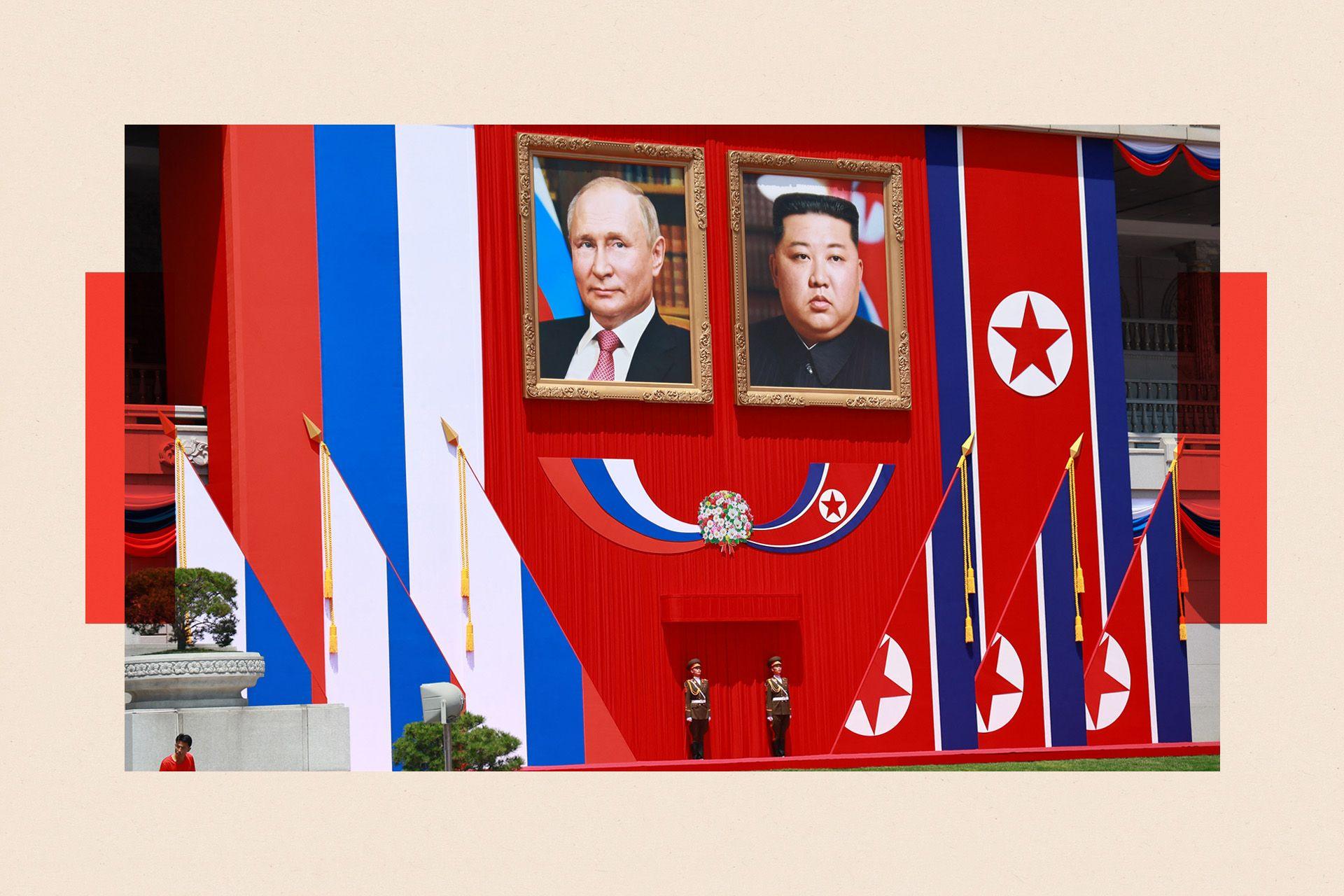 Two guards stand underneath portraits of North Korea's leader Kim Jong Un and and Russian President Vladimir Putin during a welcome ceremony at Kim Il Sung Square