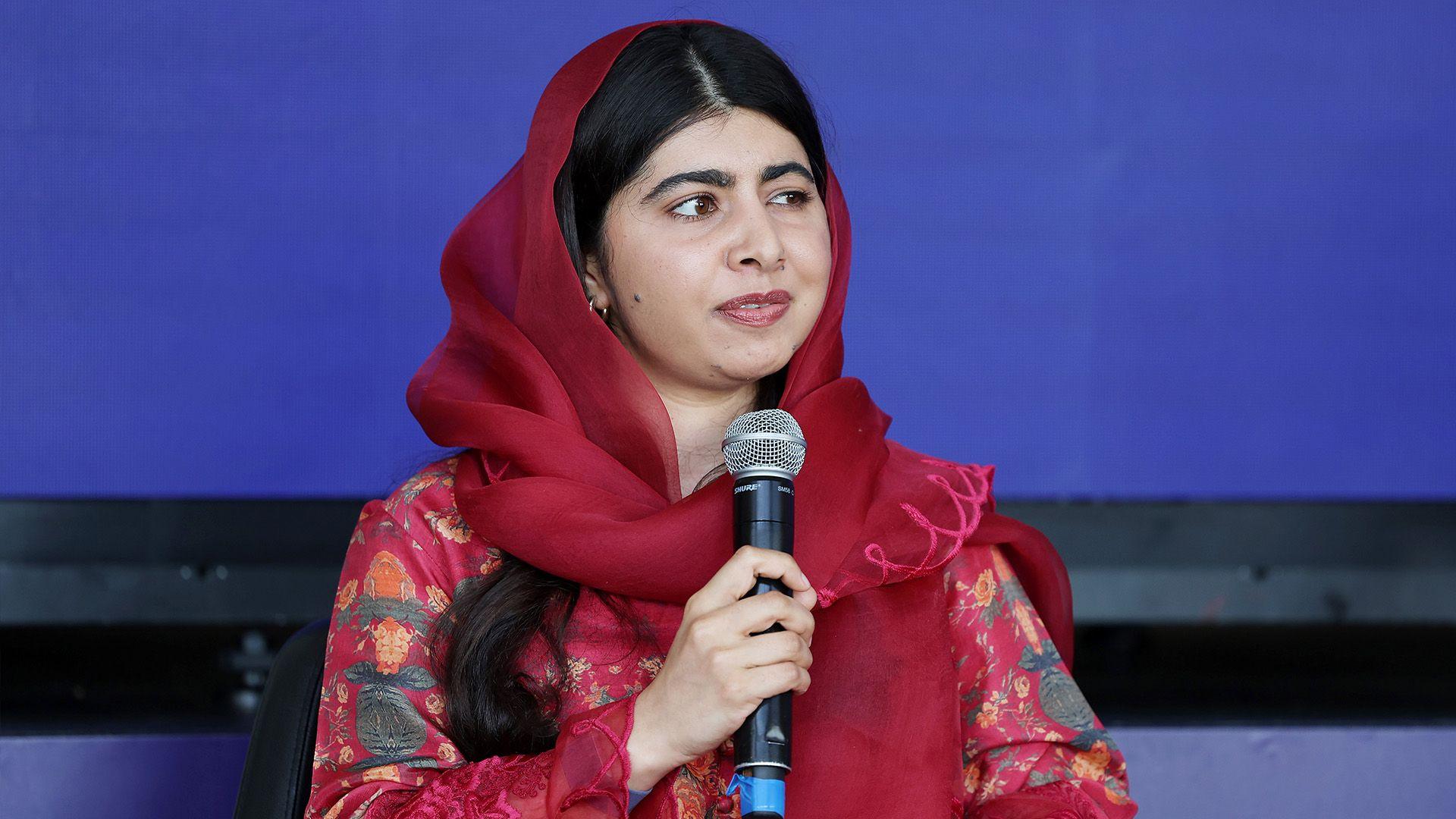 Malala Yousafzai holding a microphone.