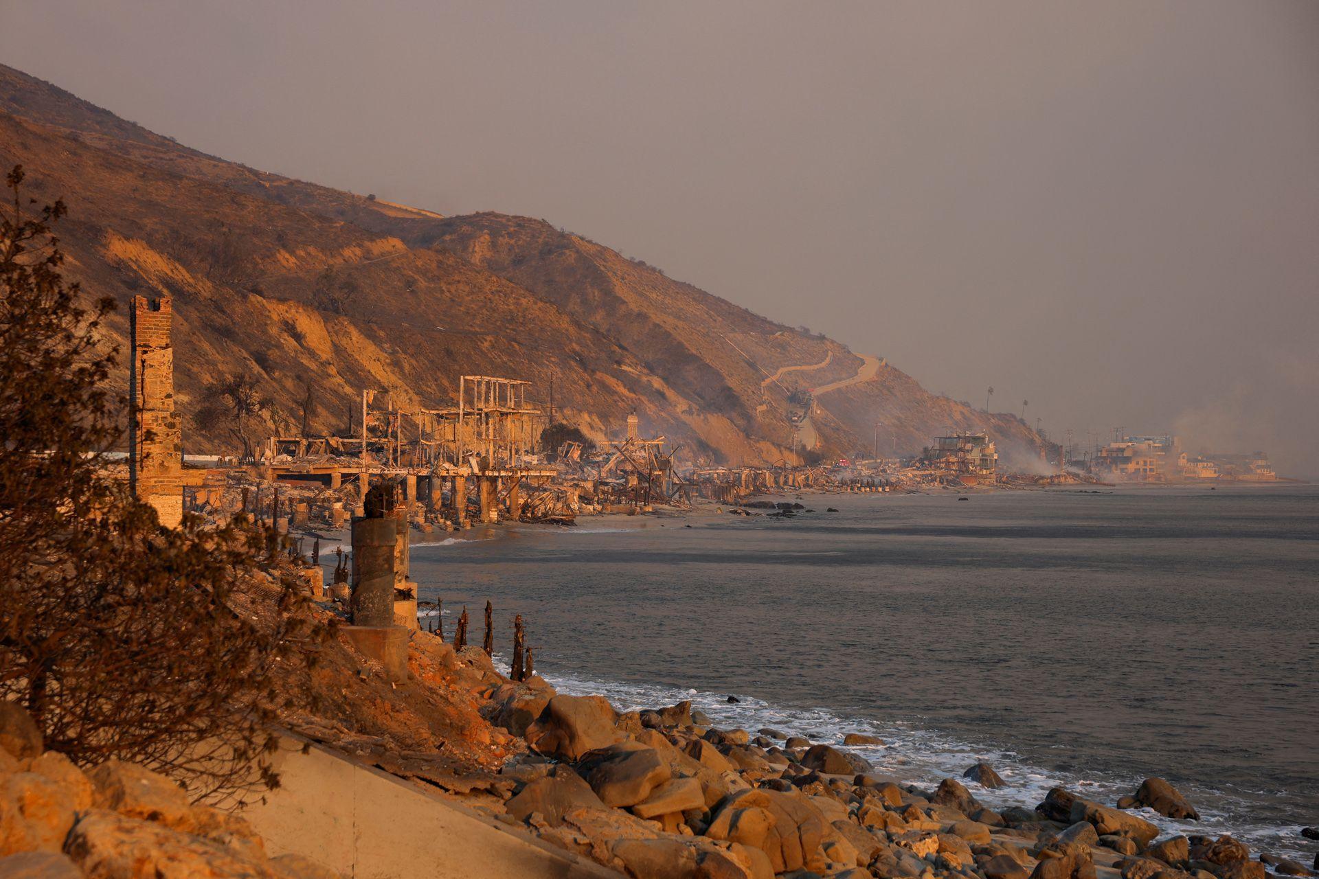 Smoke rises from burnt-down beachfront homes along the coastal road to Malibu on Wednesday, showing rows of buildings destroyed from the fires.