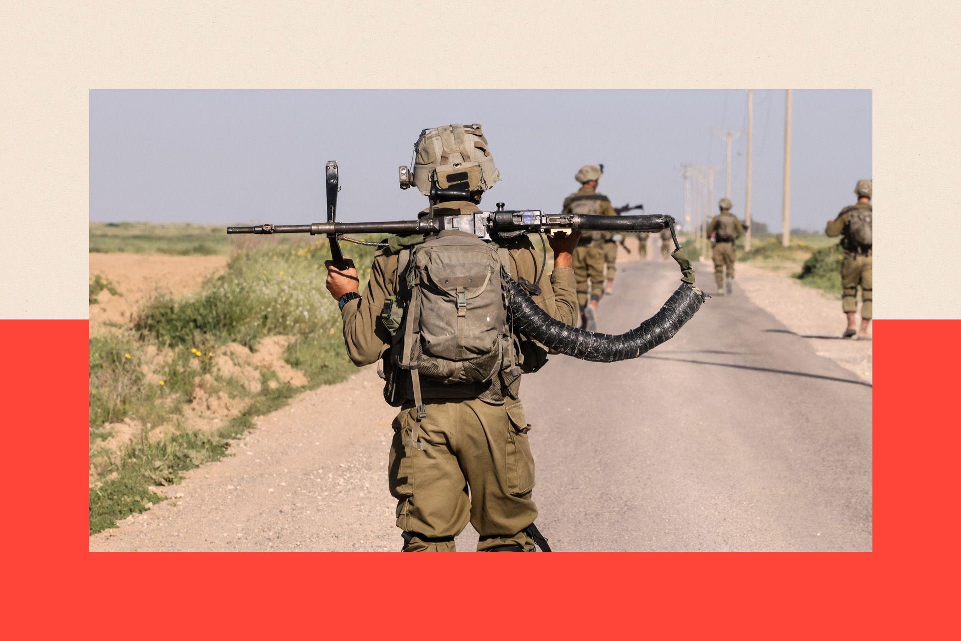 Israeli soldiers walk near the border with Gaza Strip in southern Israel, they wear green camouflage and weapons are shown