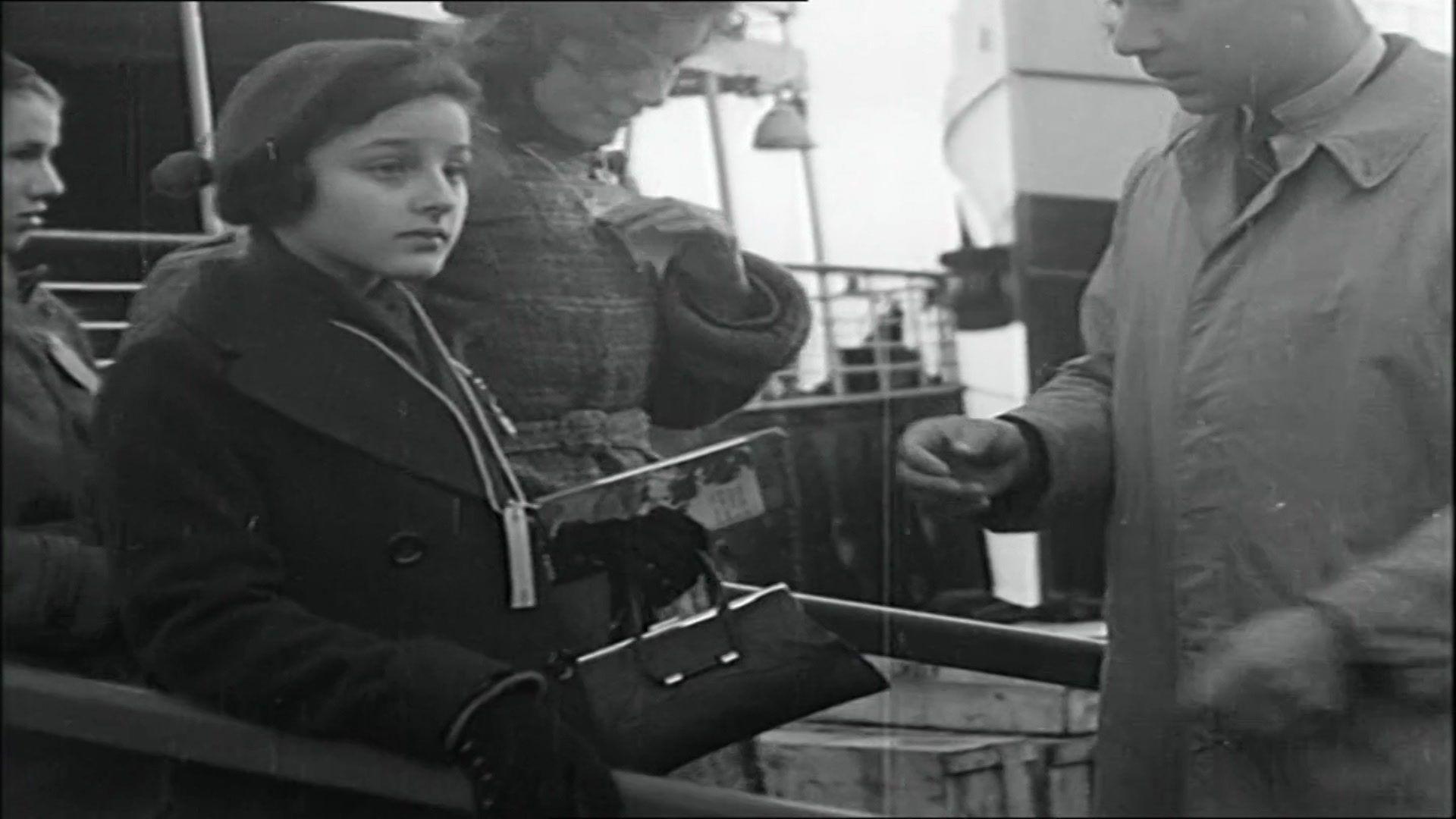 Children holding their passes and belongings leaving a boat and waiting to be checked