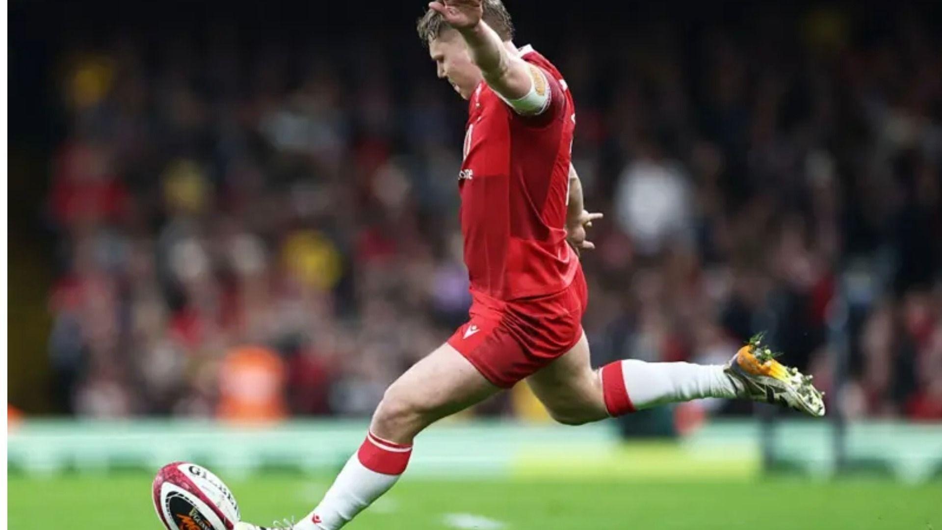 Llun o Sam Costelow yn cicio pel yn ystod y gem