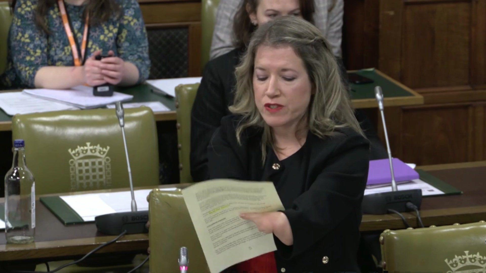 Marie Tidball holding a piece of paper in Parliament