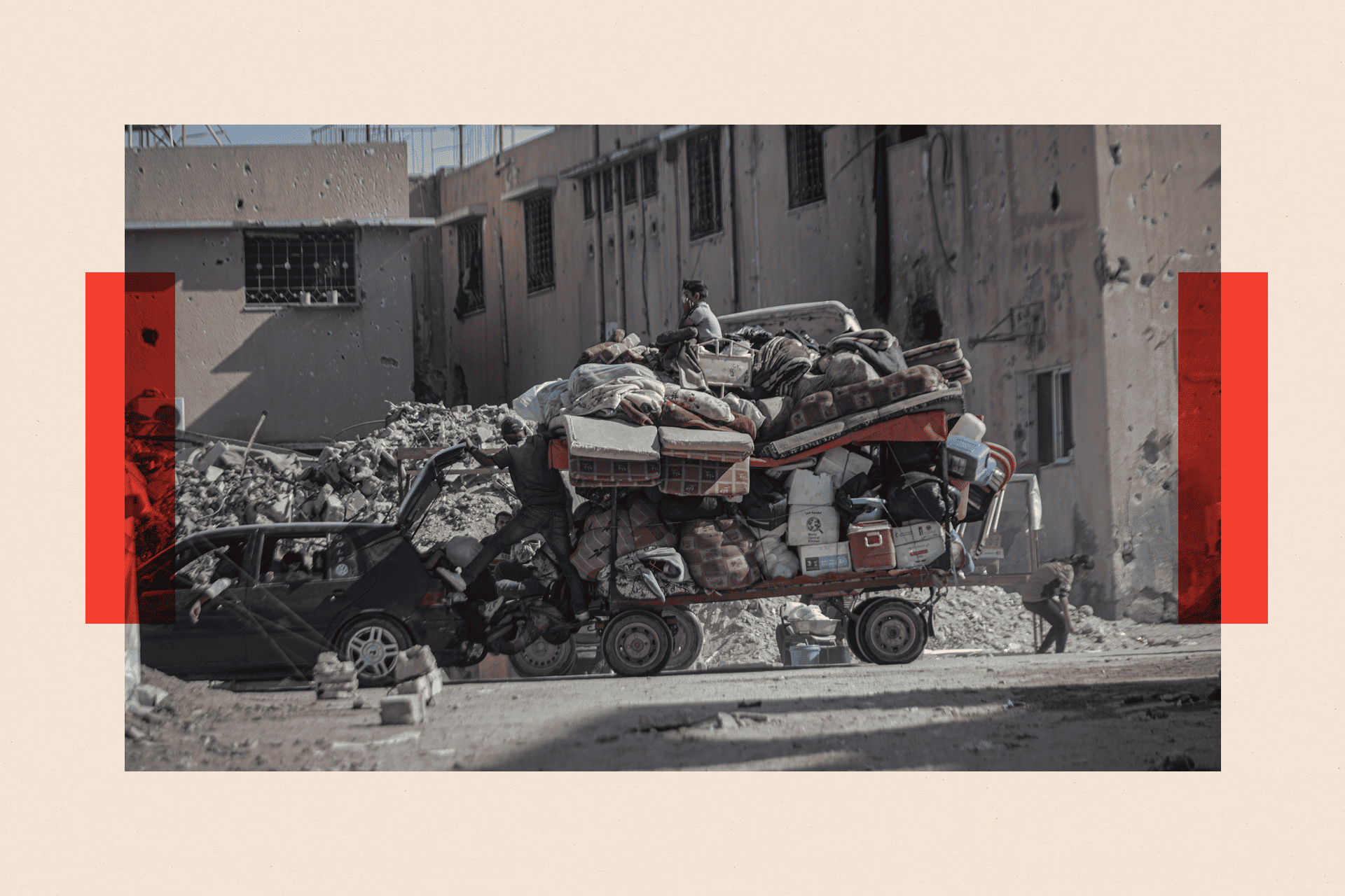 A heavily damaged neighborhood with rubble, suitcases and cars