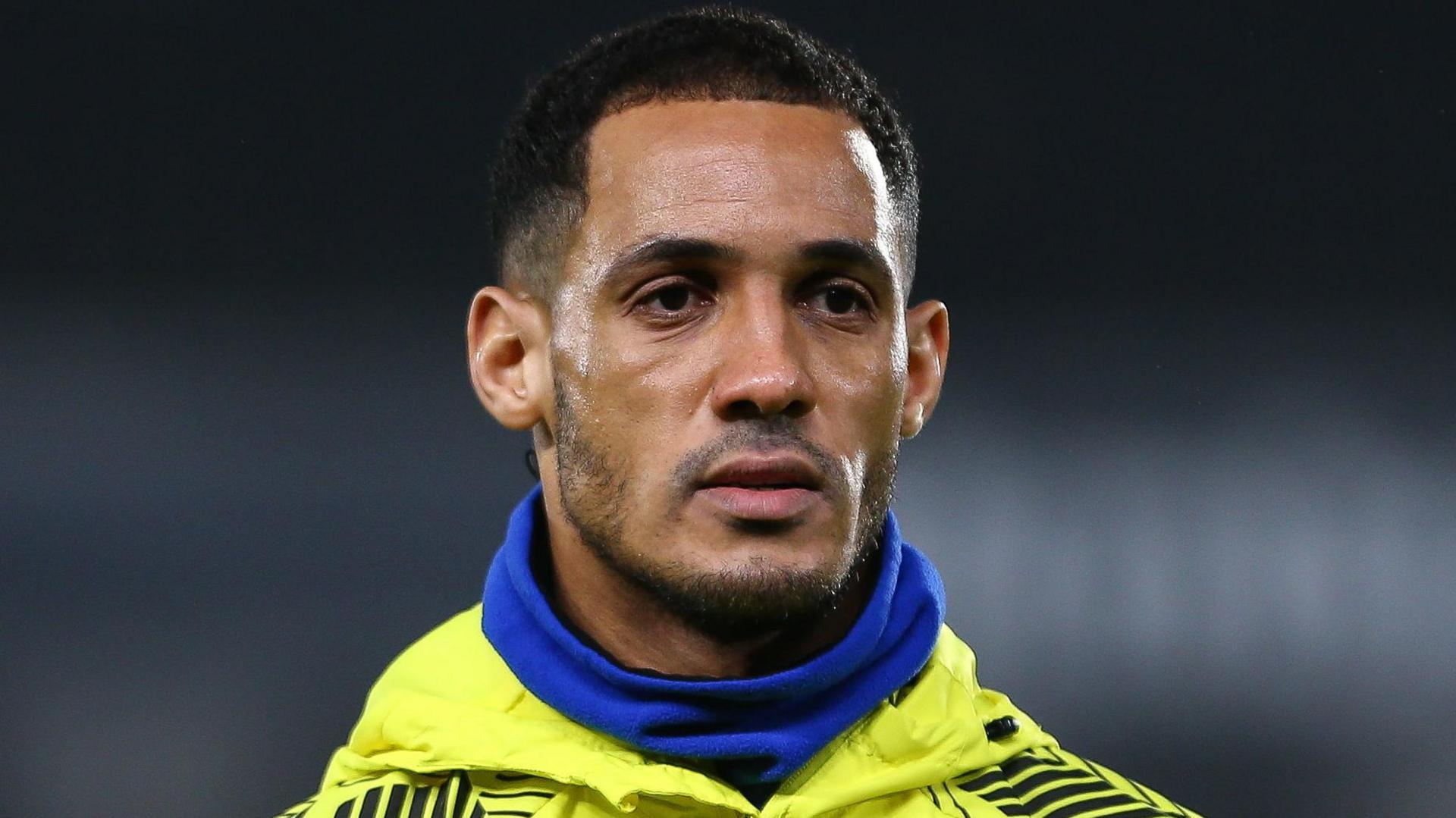 Tom Ince, wearing a blue snood and yellow Watford tracksuit top